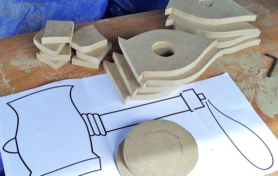 I cut out all the profiles from 3/4″ MDF. Half the head profiles have a 1.75″ hole drilled into them for the handle. Two disks of MDF were glued together and then sanded down to a thickness of 1″. I sanded a 15º bevel to the side.