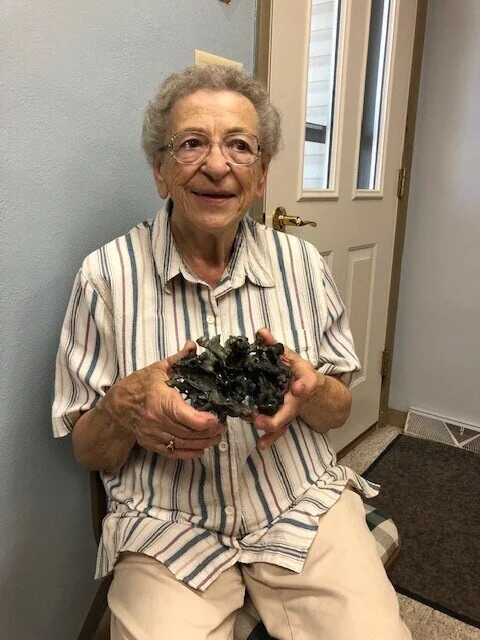 Jane Mleziva, long-time St. Thomas the Apostle parishioner, with a fragment of the bell tower that remains from the St. Hubert fire of 1966.