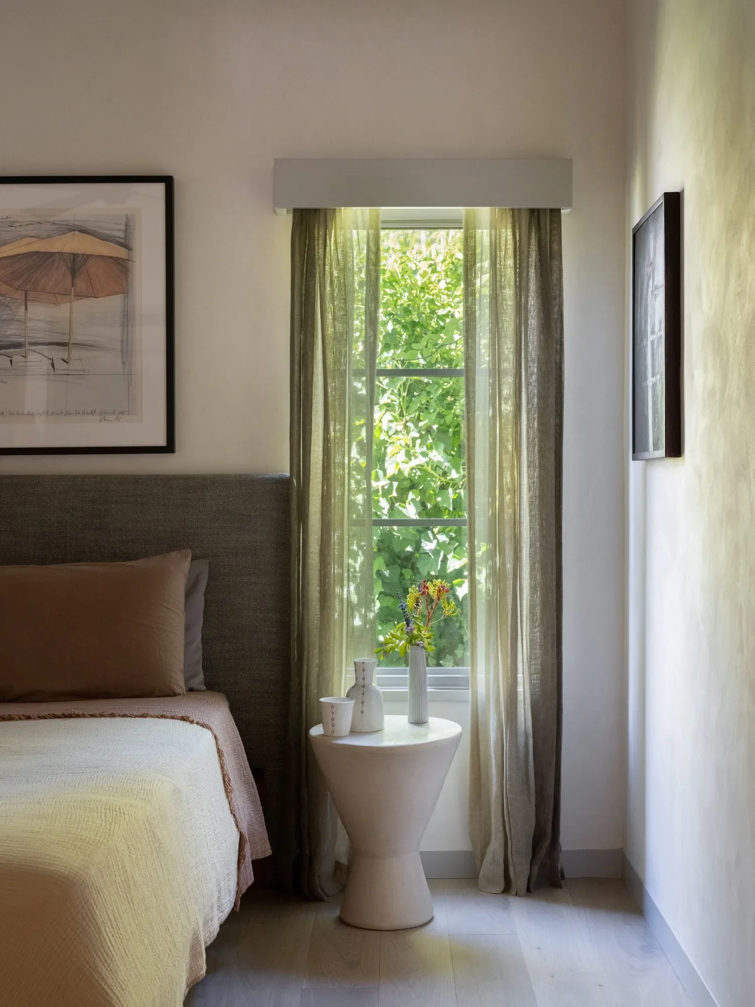 The subtlety of hand-painted ombré sheers together with clay walls, muted colors of the bedding and simple form of the tadelakt bedside table is exemplary of the consistently understated and carefully assembled compositions repeated throughout the ho