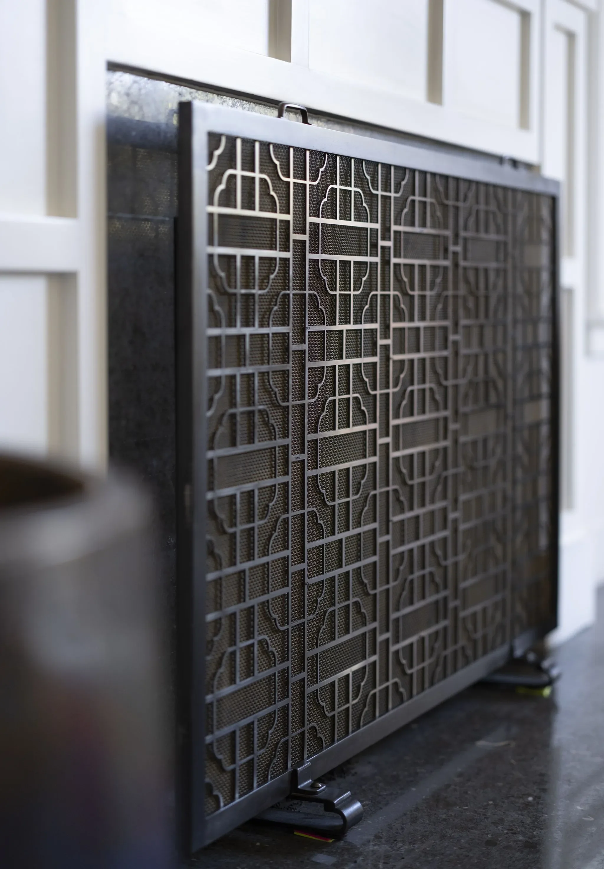 Close-up of a metallic appliance with a decorative grating on a dark countertop.