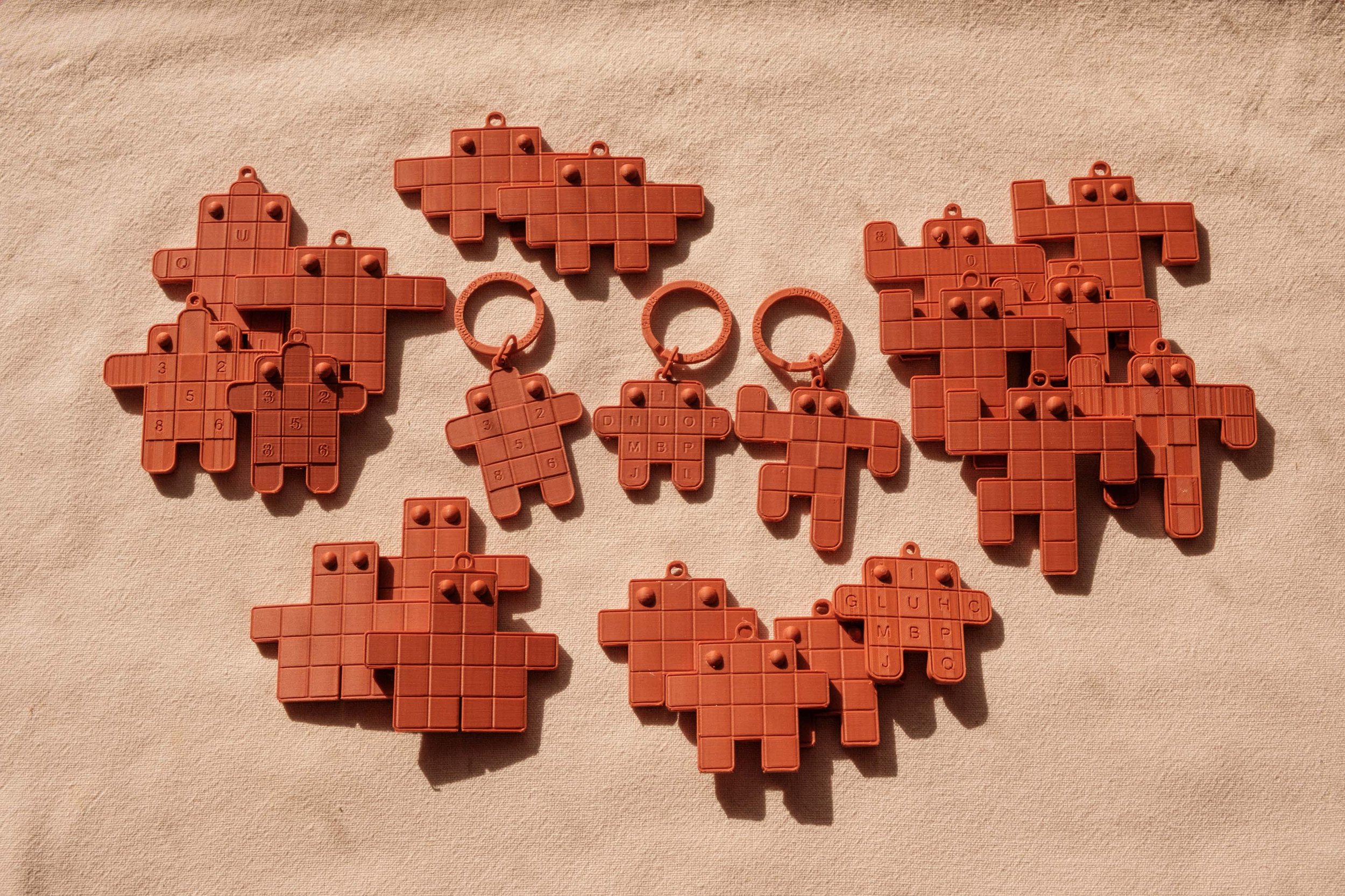 Multiple Tetris-like game pieces, some with letters and numbers, on a light-colored fabric surface.