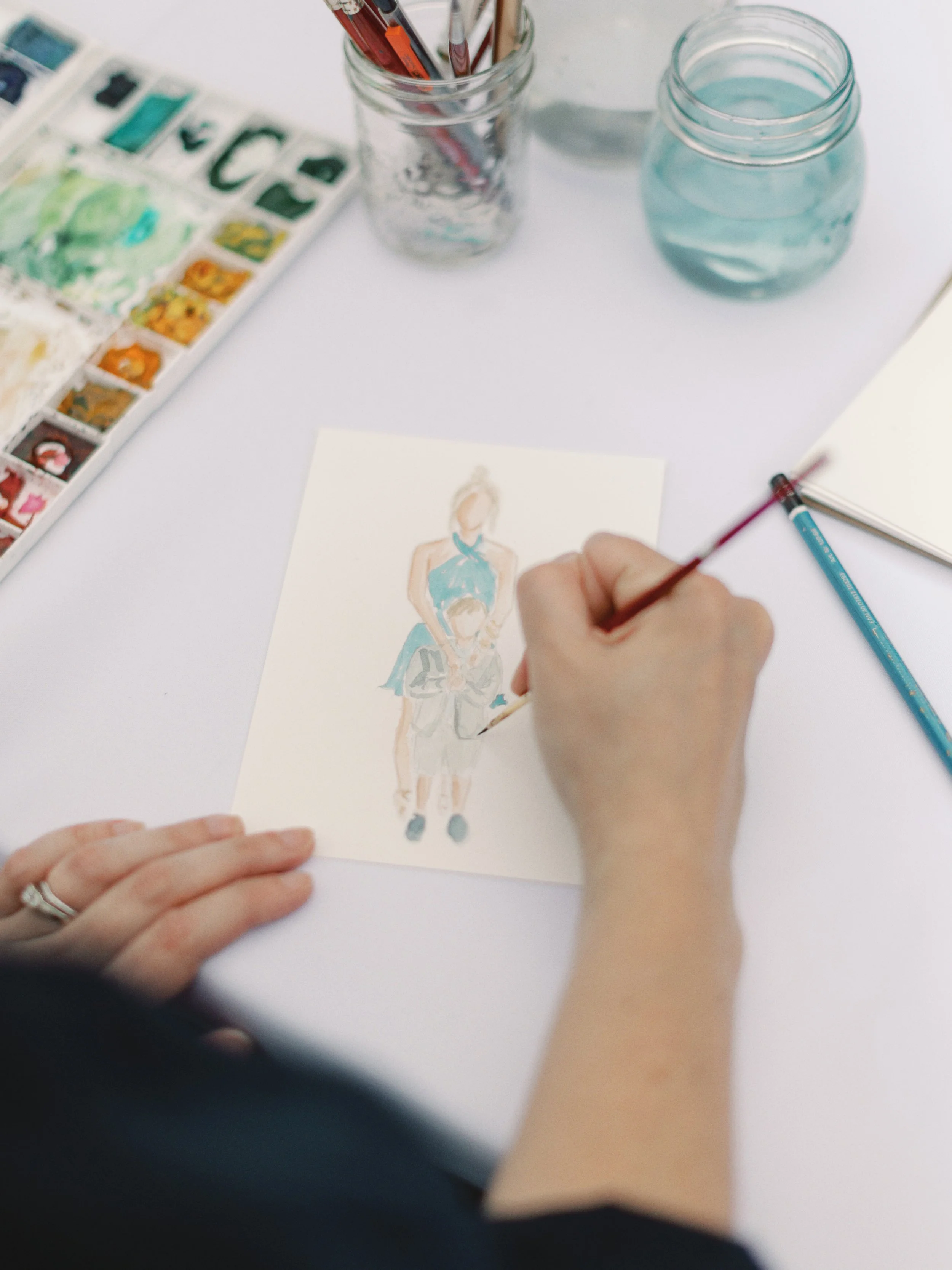 Artist Amanda Donahue of The Scribblist painting live watercolor portraits at a wedding in the Portland, Oregon area.