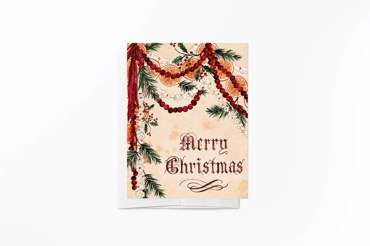 Vintage-style Merry Christmas card with watercolor garlands of cranberries, dried orange slices and popcorn, pine, holly and a red ribbon, with Merry Christmas in old-world calligraphy on aged cream p