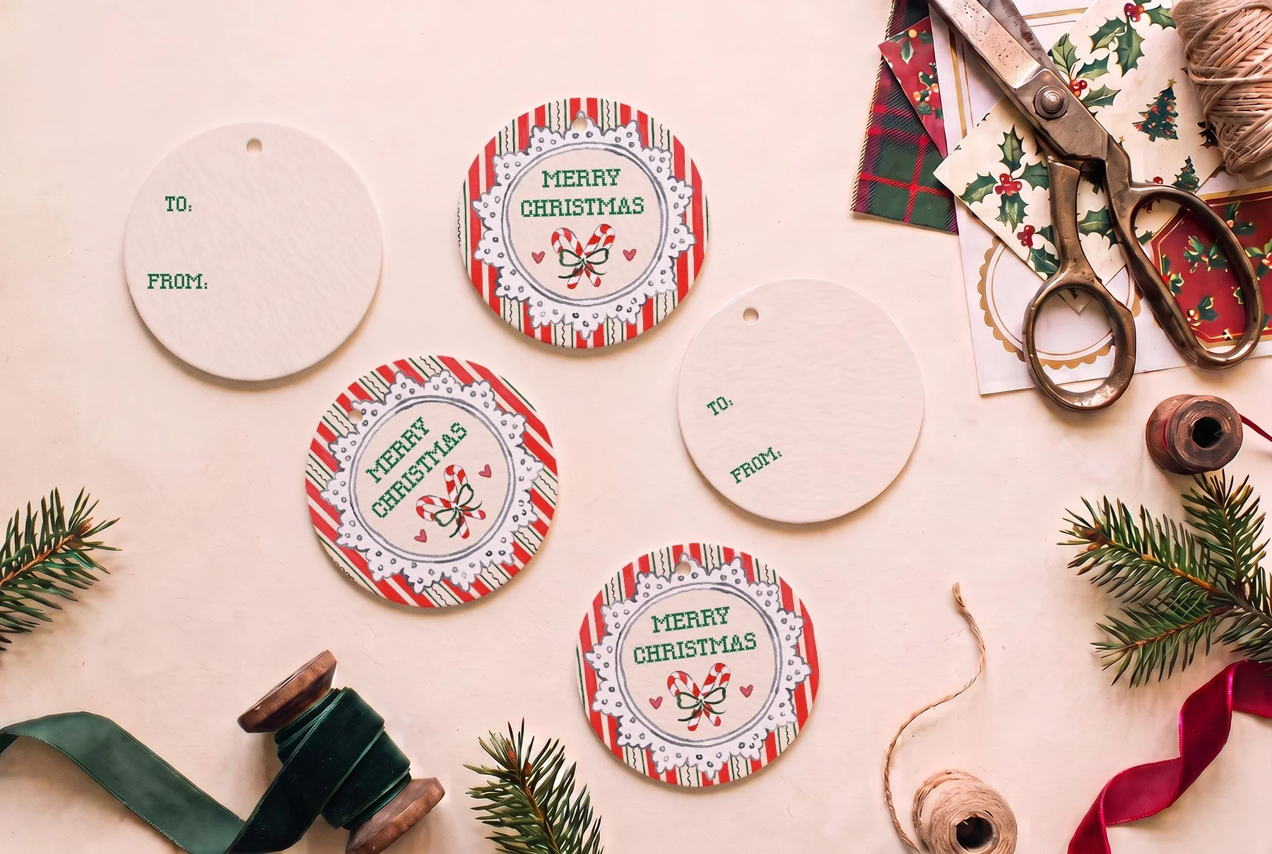 Round Christmas gift tag with green cross-stitch Merry Christmas lettering and crossed candy canes inside a white lace doily frame on red and green candy cane stripes