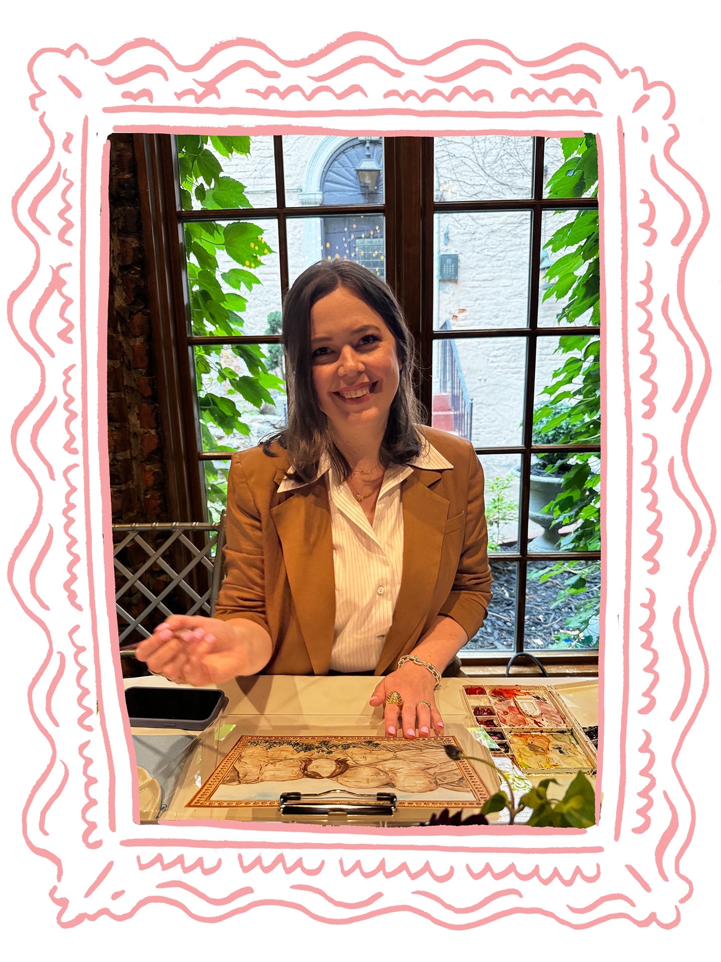 Artist Amanda Donahue of The Scribblist is shown painting live watercolor portraits at an event in New York City, surrounded by a hand-illustrated frame in pink.