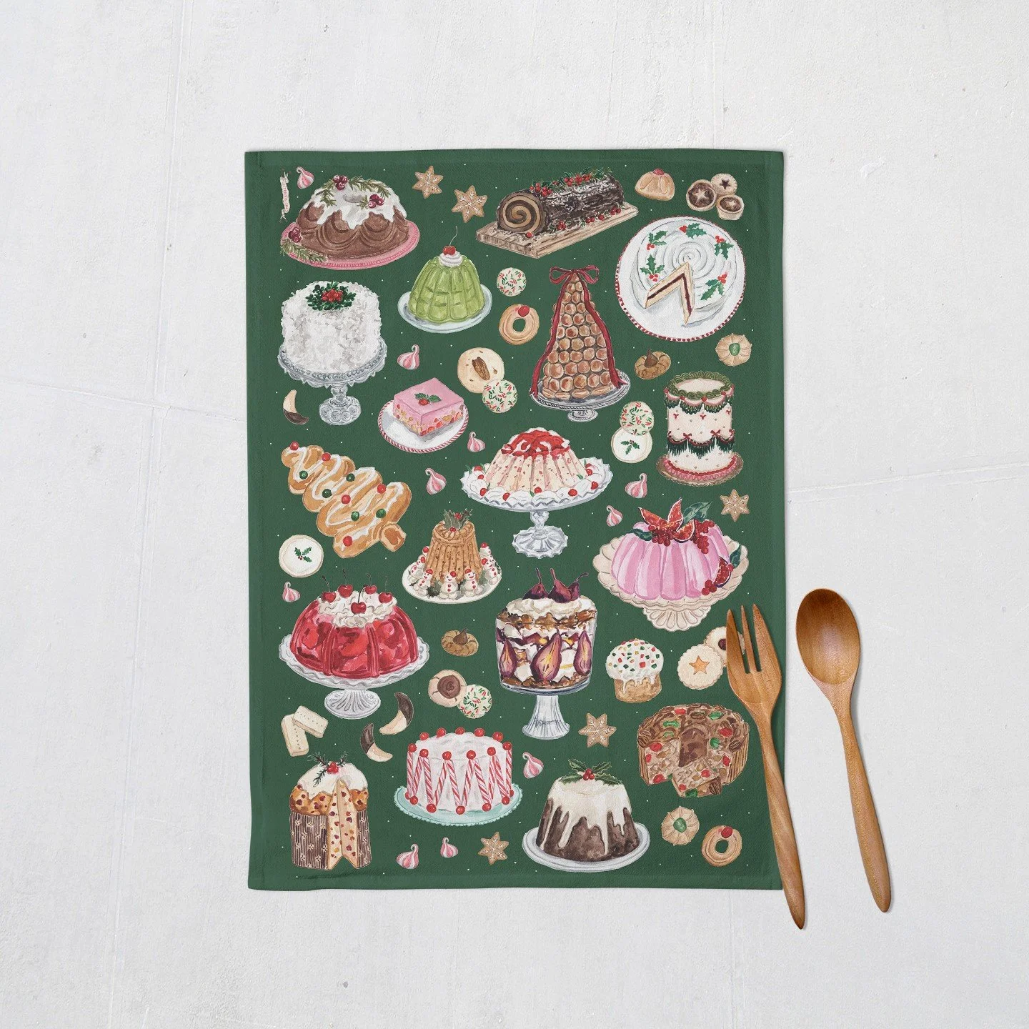 Vintage Christmas Desserts Tea Towel shown flat with wooden utensils