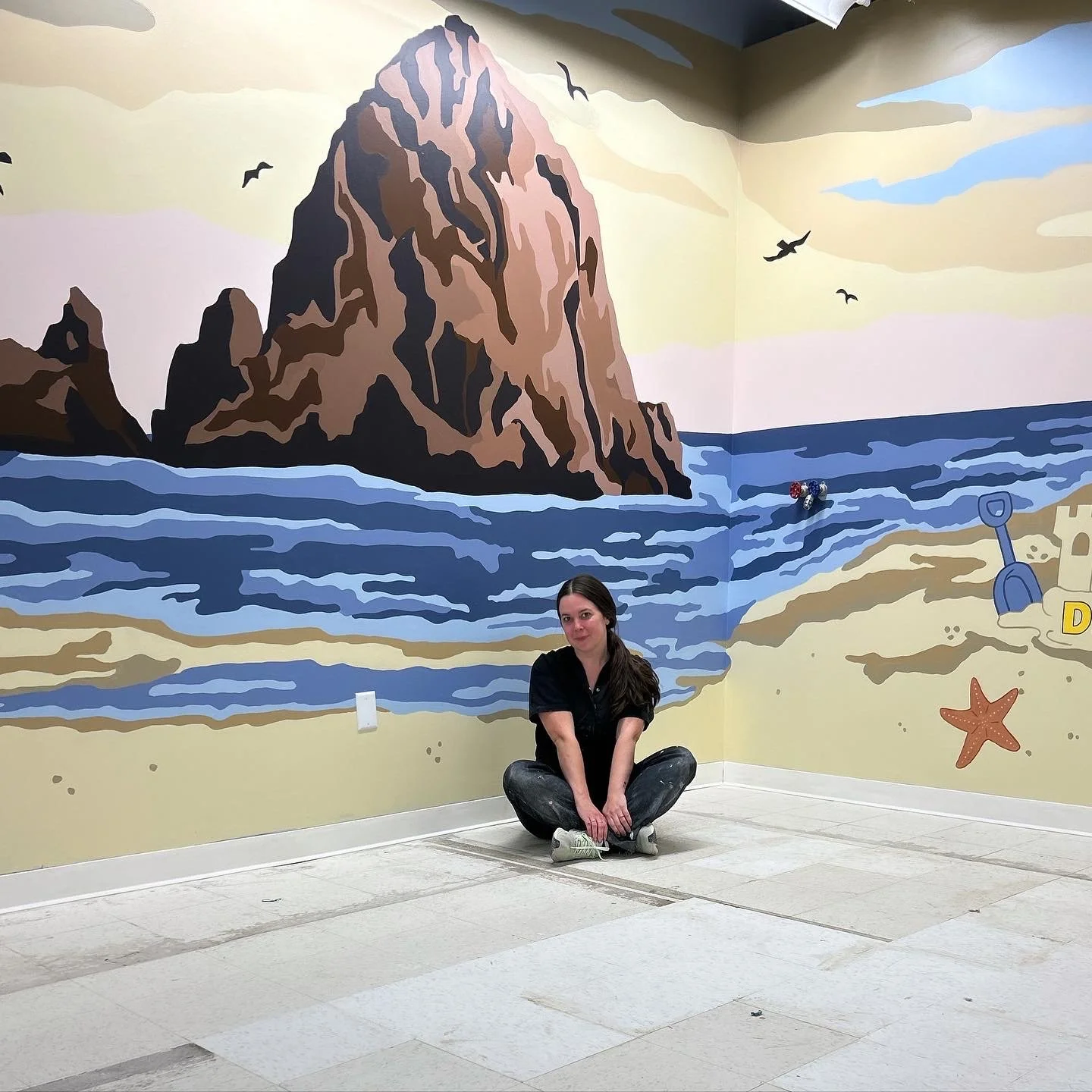 Oregon artist Amanda Donahue of The Scribblist with her coastal mural featuring Haystack Rock at DigPDX in Portland