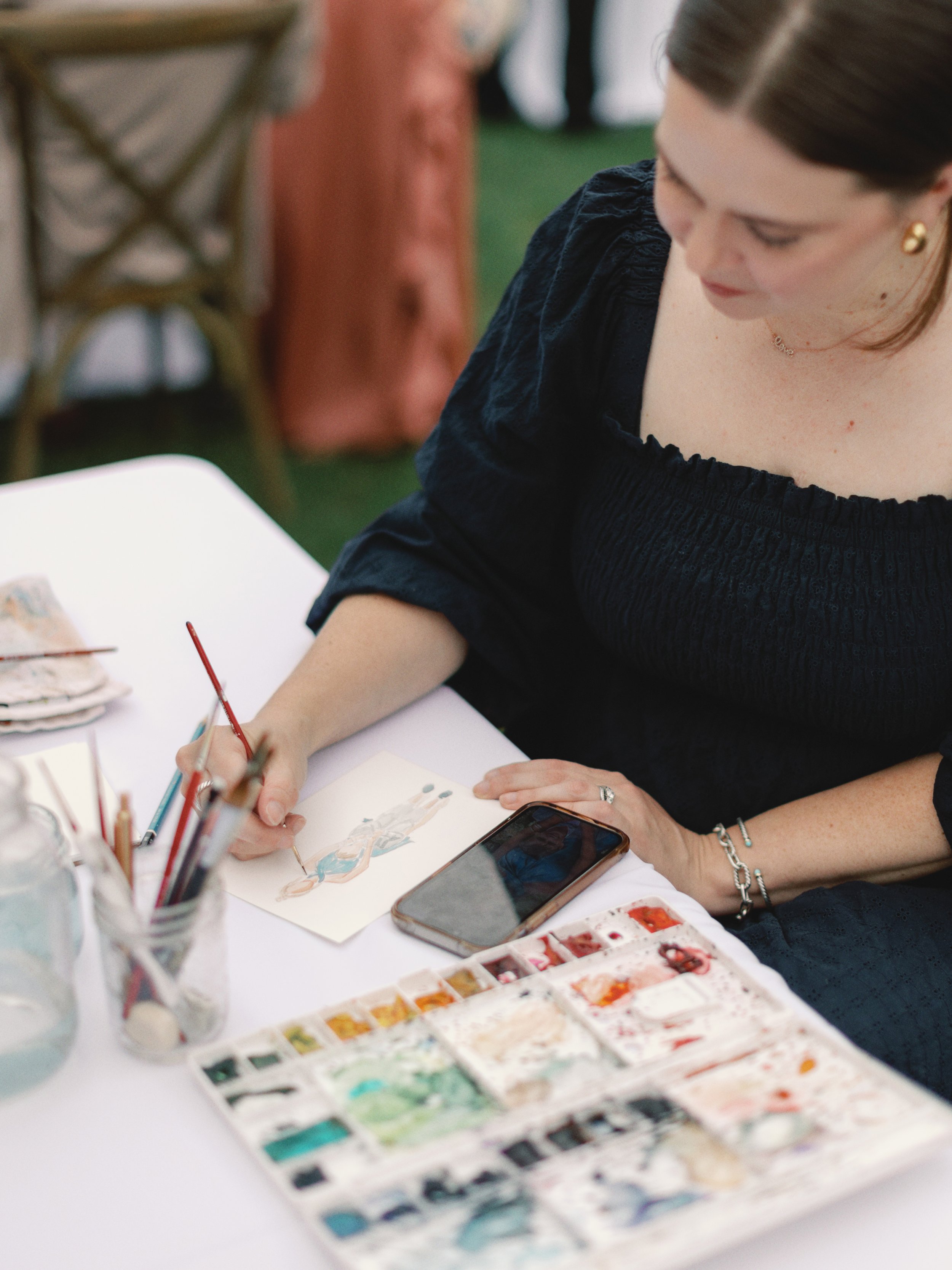 Artist Amanda Donahue of The Scribblist paints live watercolor portraits at an event in Oregon