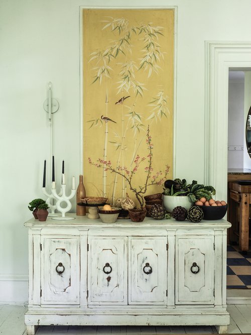 Dining Room - White distressed sideboard styled with farm fresh foods highlighting the hand painted inset murals