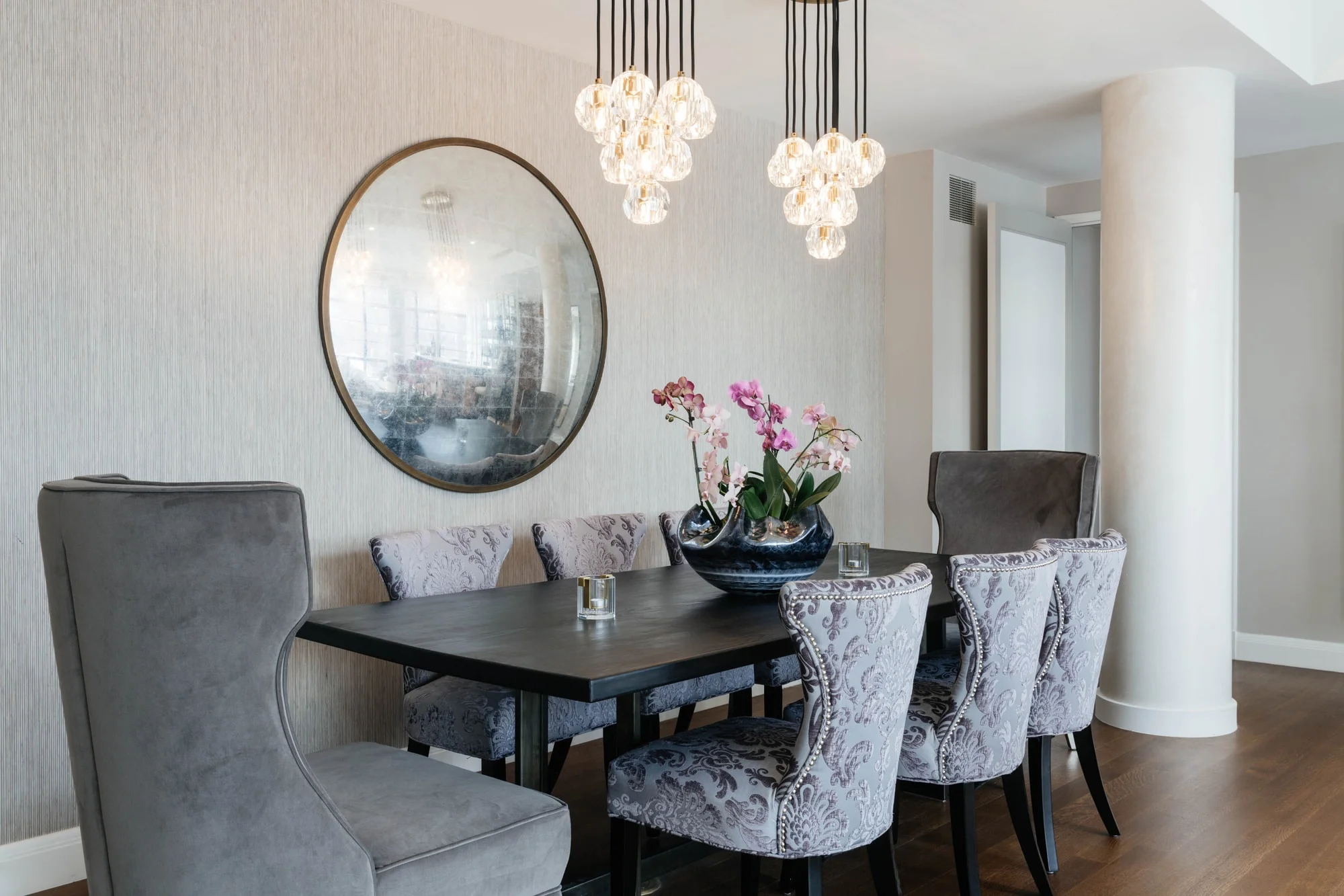 Dining room space with convex mirror hanging on wall