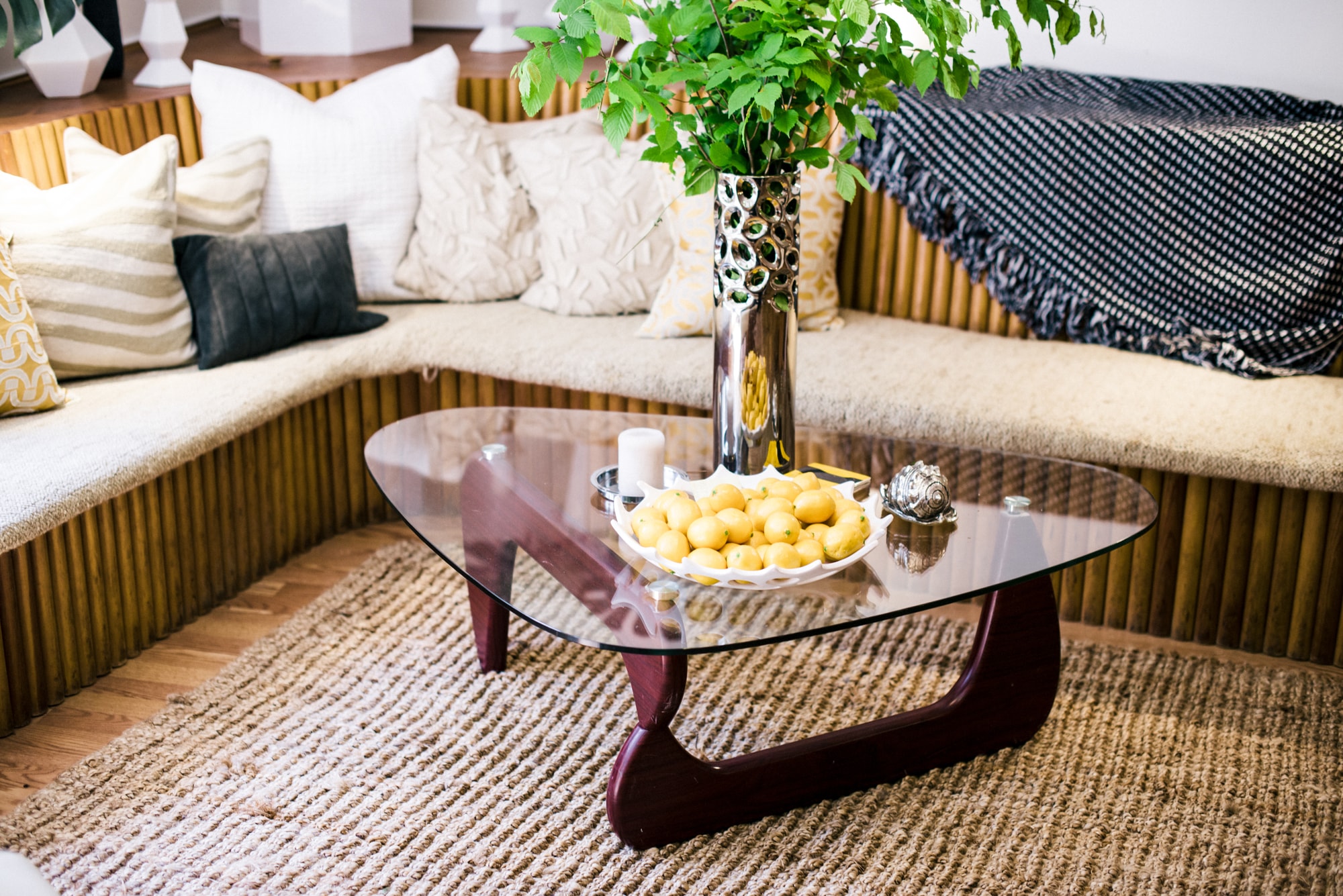 Triangular glass coffee table with dish of fruit