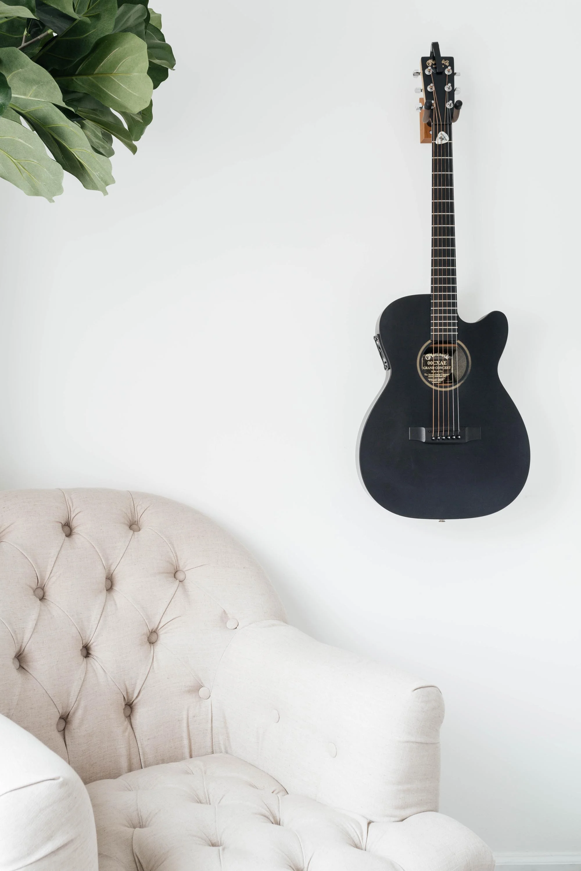 Soft white sofa with dark blue guitar hanging on wall