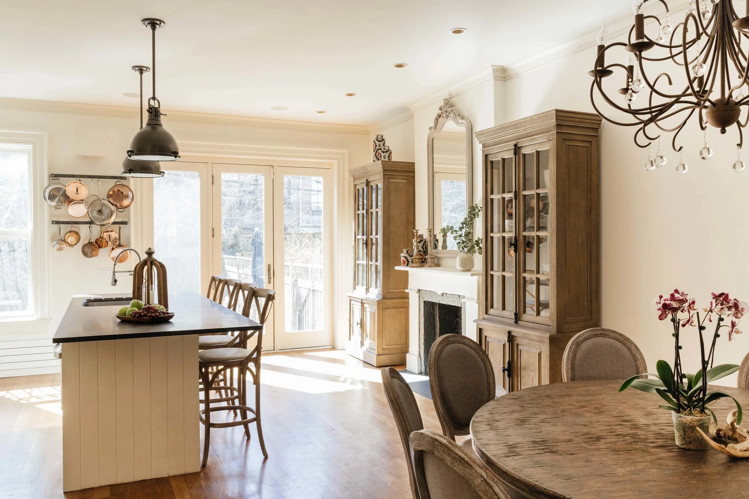 Rustic kitchen with round table and mirror above a fireplace