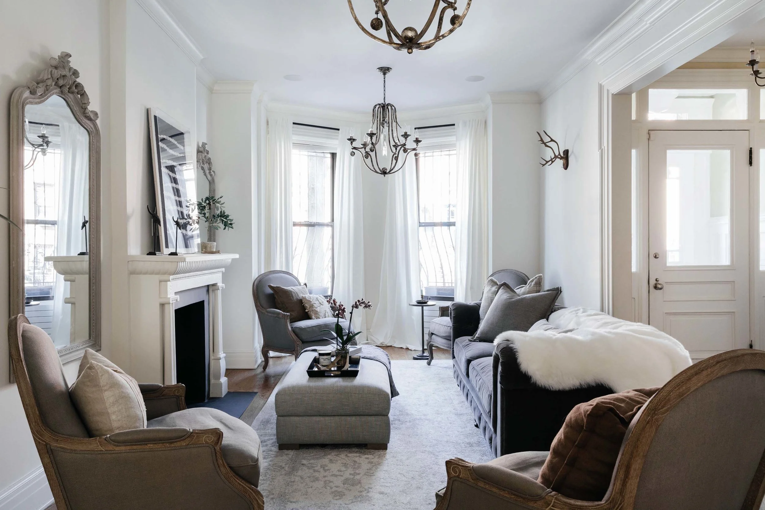 Bright living room area with plush seating and flowers on an ottoman