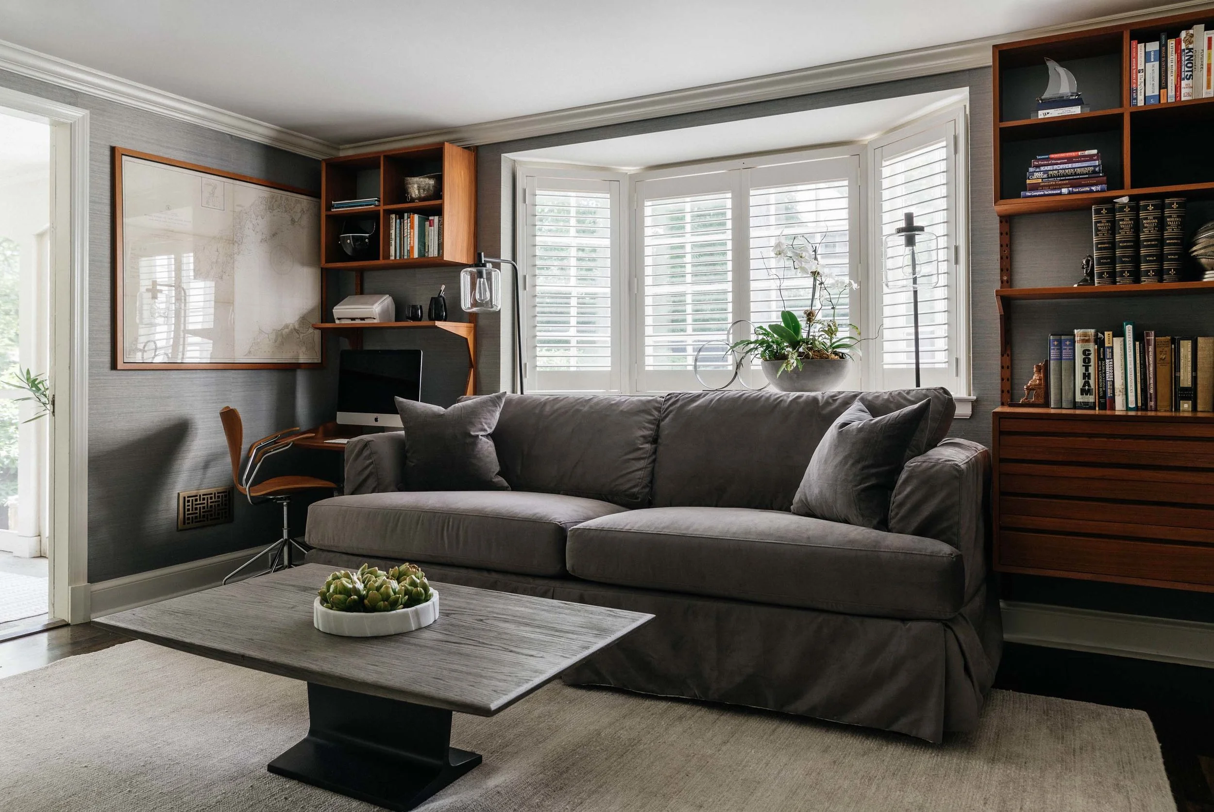 Living room with sofa, center table and wooden shelves with books