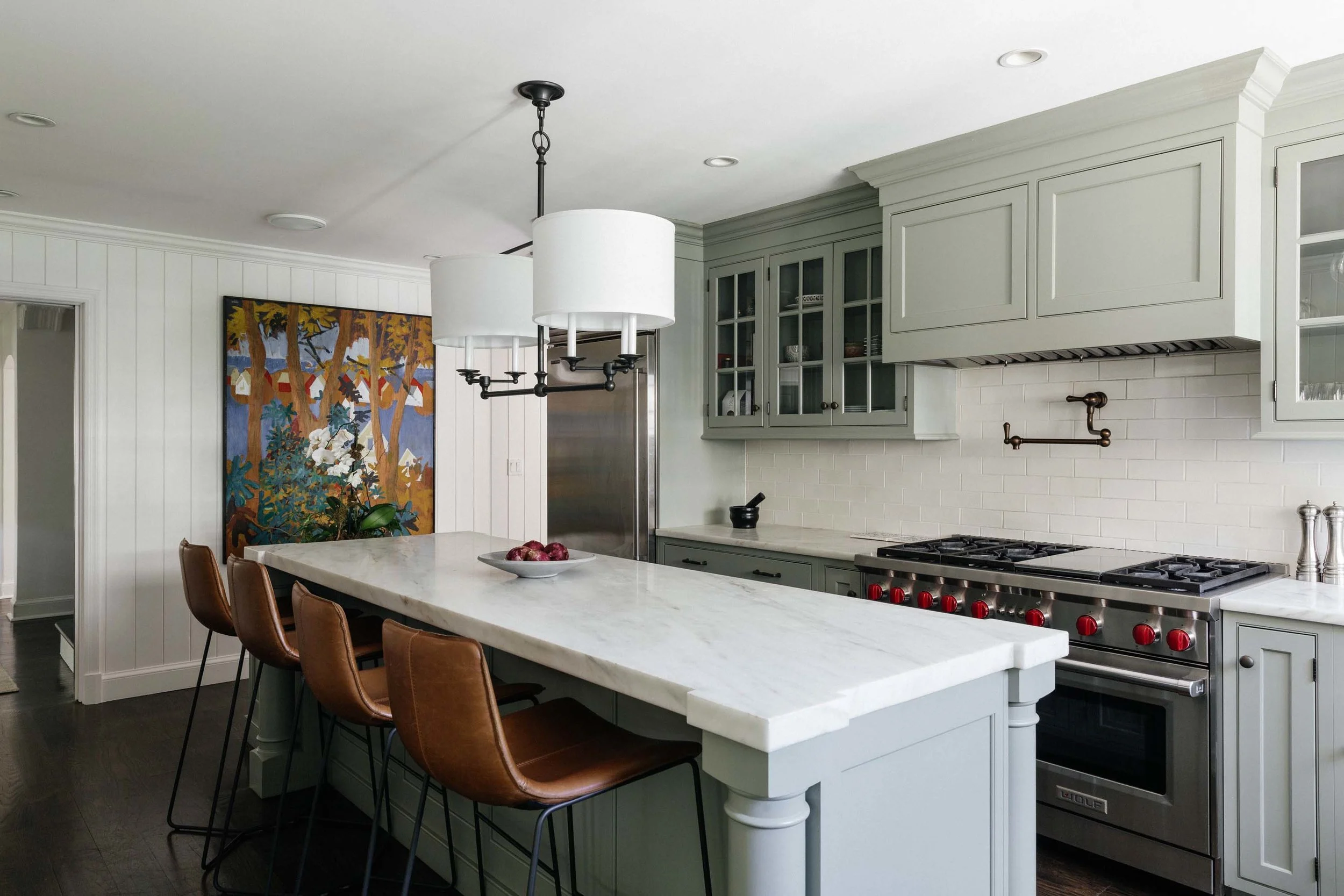 Kitchen with ceramic center island, chairs, stove and wooden cabinets