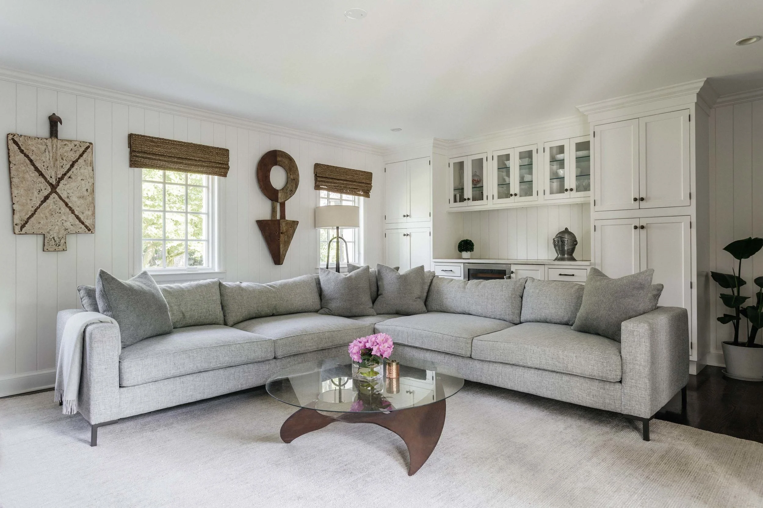 Living room with large sofa, glass center table and wooden cabinets