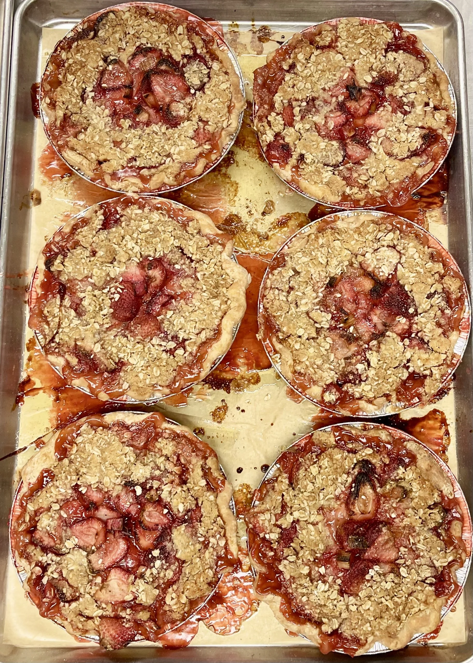 ix homemade strawberry rhubarb pies cooling in the OFT farm kitchen, made with locally sourced strawberries and rhubarb for Mother's Day.