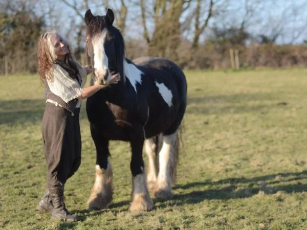 Liz Meadows standing in a field with a horse