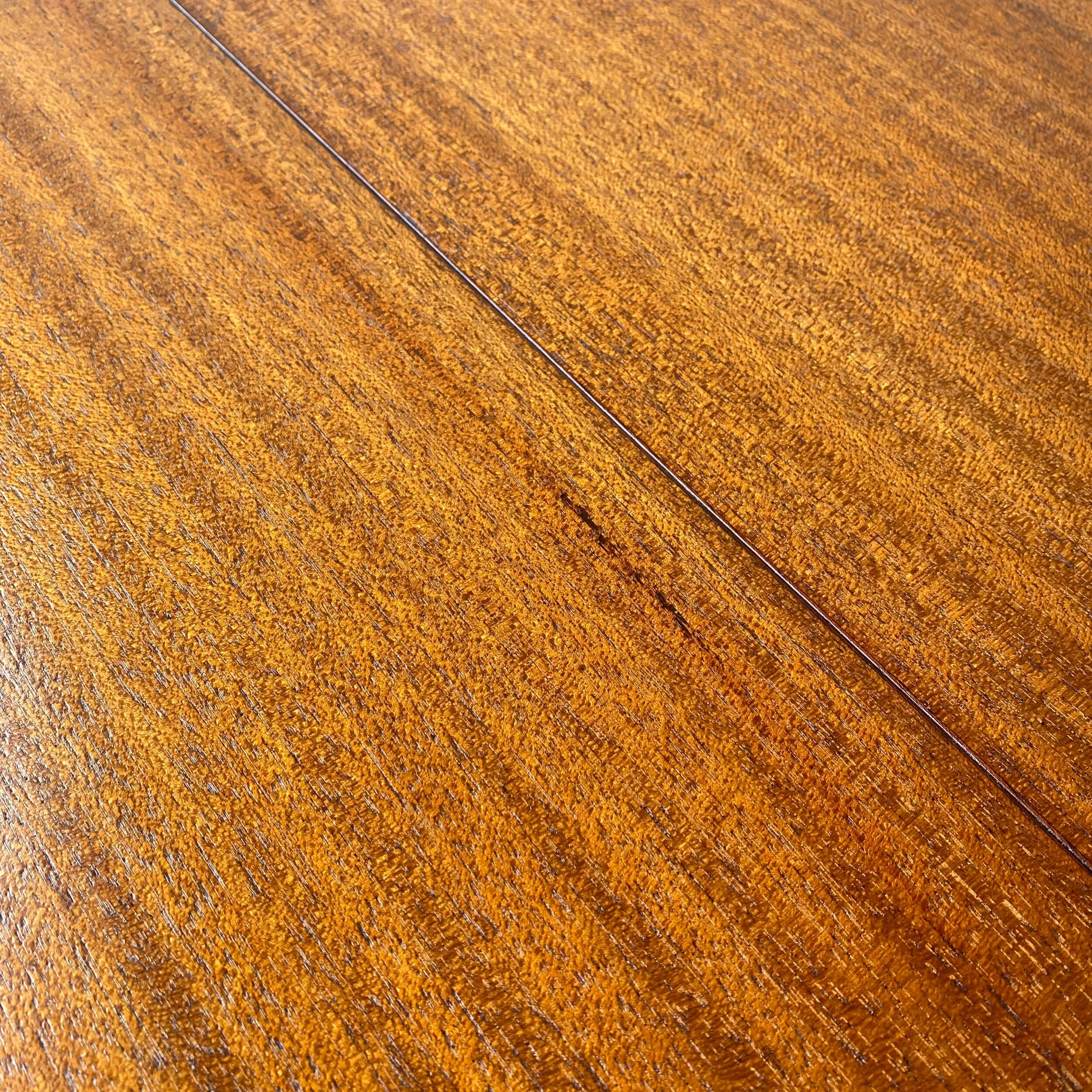 A stunning mahogany dining table with black lacquered saber leg base.  A mid century modern classic from Harvey Probber.   Newly refinished with minor imperfections from age and use