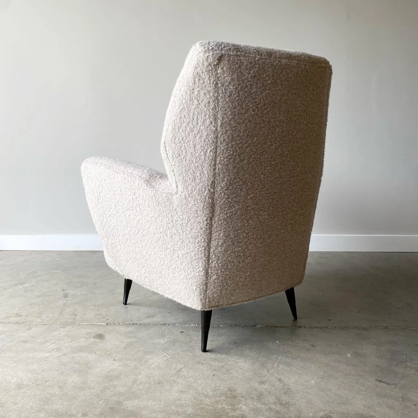 Back view of A dynamic pair of mid century Italian armchairs. In the style of Gio Ponti these have a cozy feel and sculptural silhouett