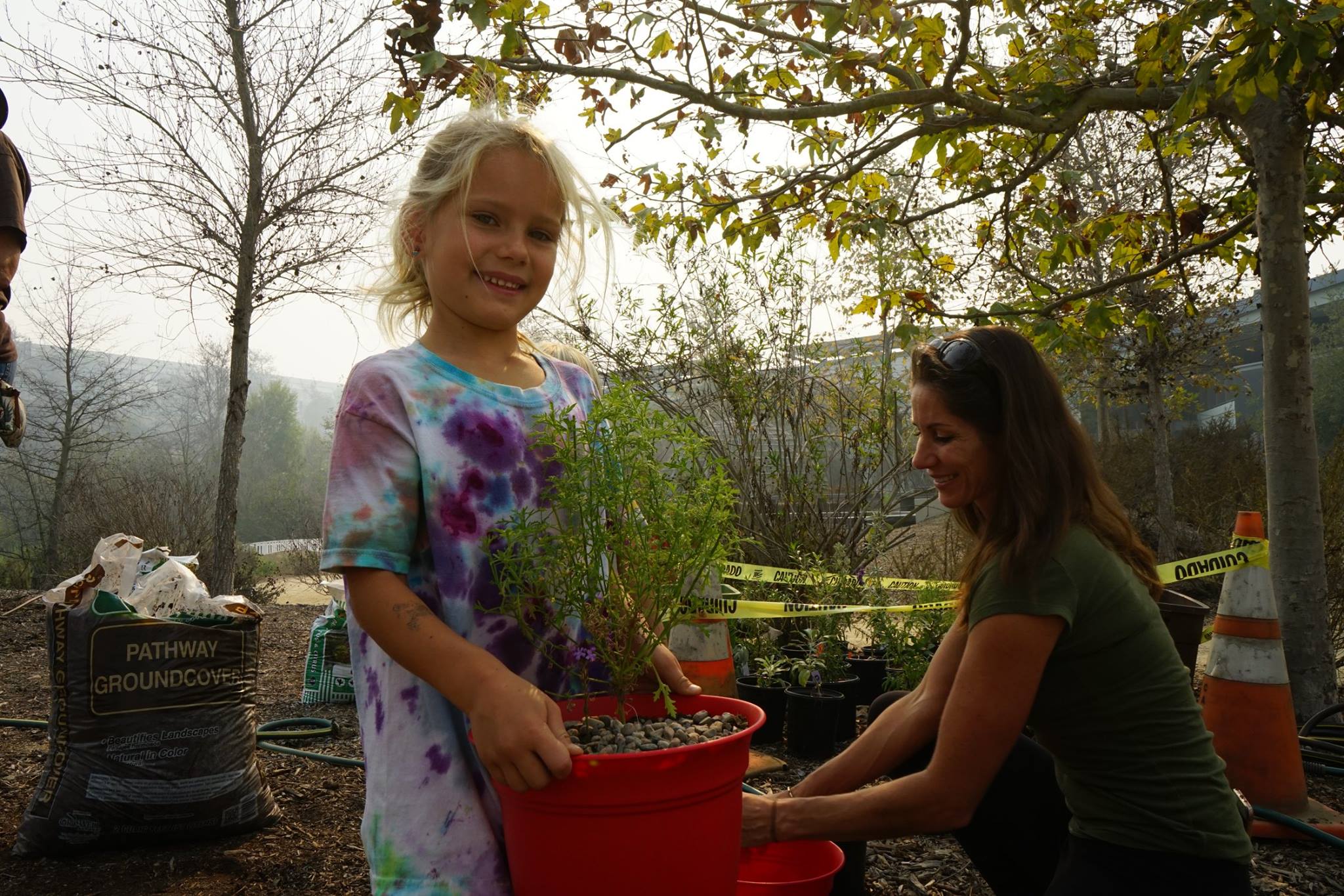 Young girl holding a potted plat at Grow Native Event (Copy) (Copy)