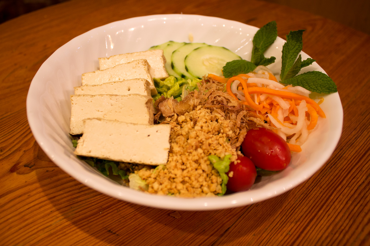 Tofu green salad topped with variety of greens and peanuts