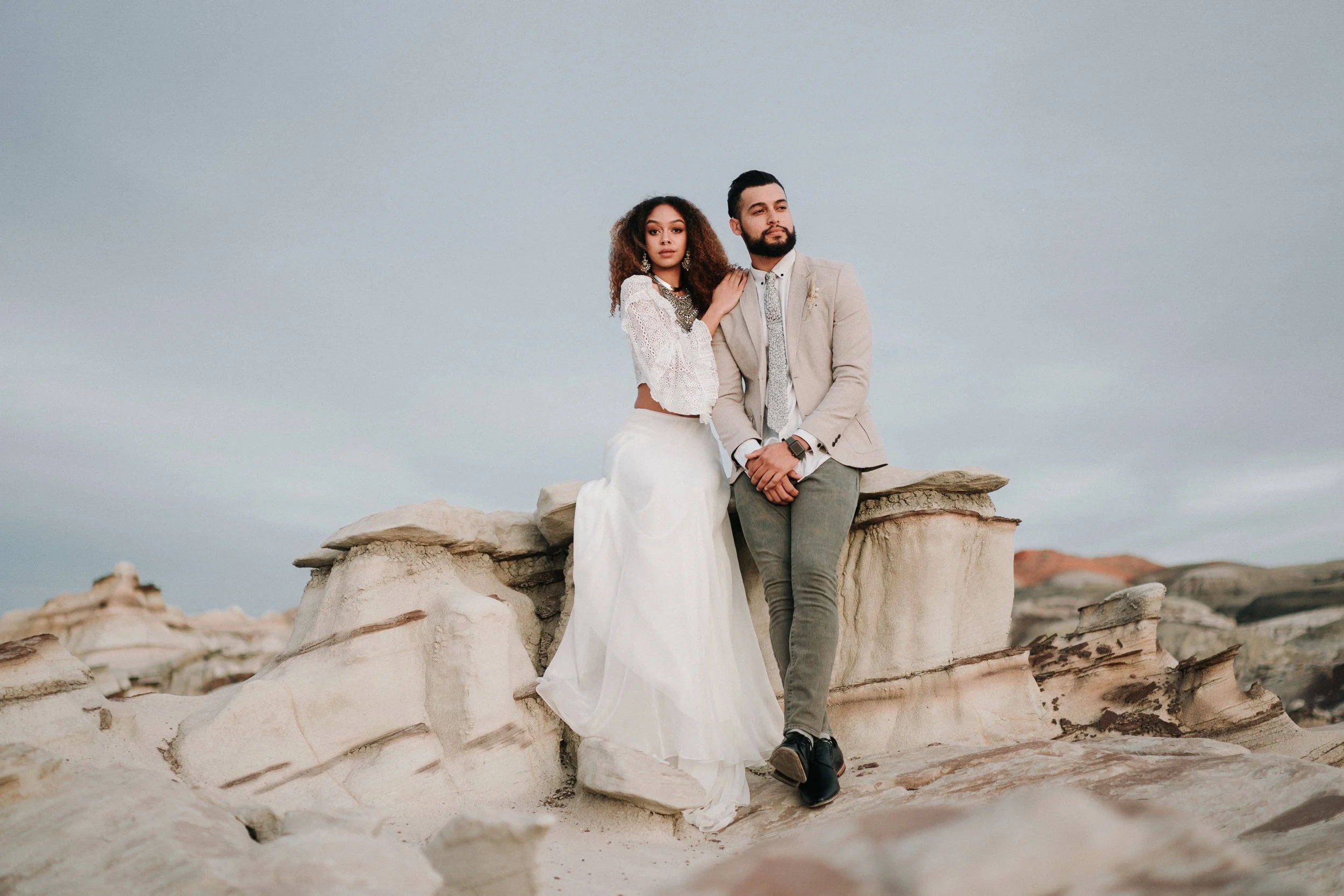 Couple embracing with a dramatic high desert landscape in Central Oregon, photographed by Bend wedding and elopement photographer Tony Gambino.