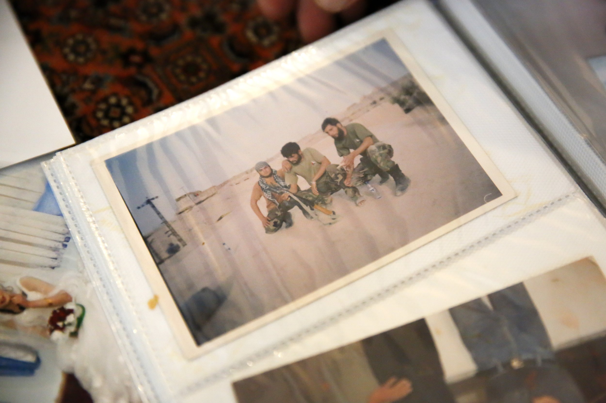  A photo of Najibullah Mohammadi and two of his military team members is seen in a family photo album at the Mohammadi’s home in Sacramento, Calif. on Sunday, September 12, 2021. Najibullah Mohammadi, his wife Susan, their two young children Zahra an