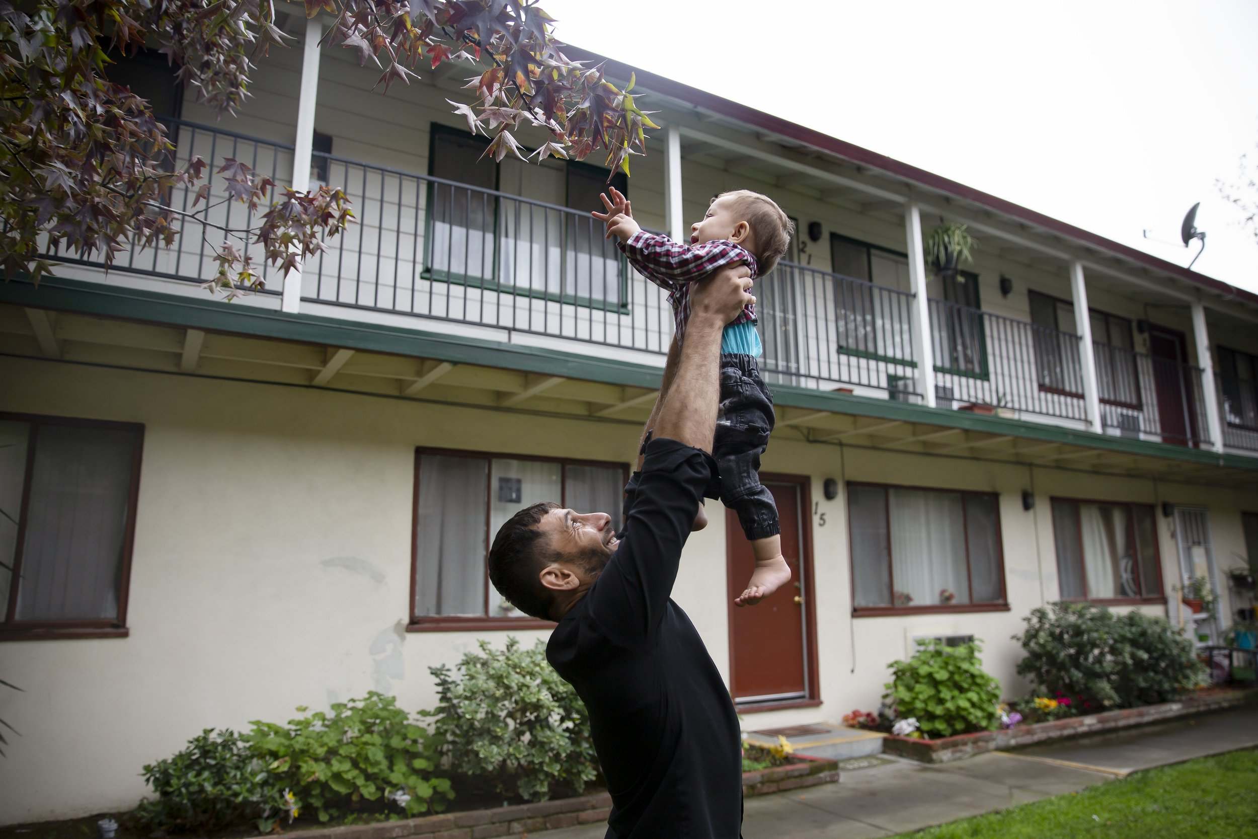  Najibullah Mohamamdi holds his one-year-old son Yasar up in the air  to play with tree leaves outside their one bedroom apartment in Sacramento, Calif. on Saturday, November 13, 2021. Najibullah Mohammadi, his wife Susan, their two young children Za