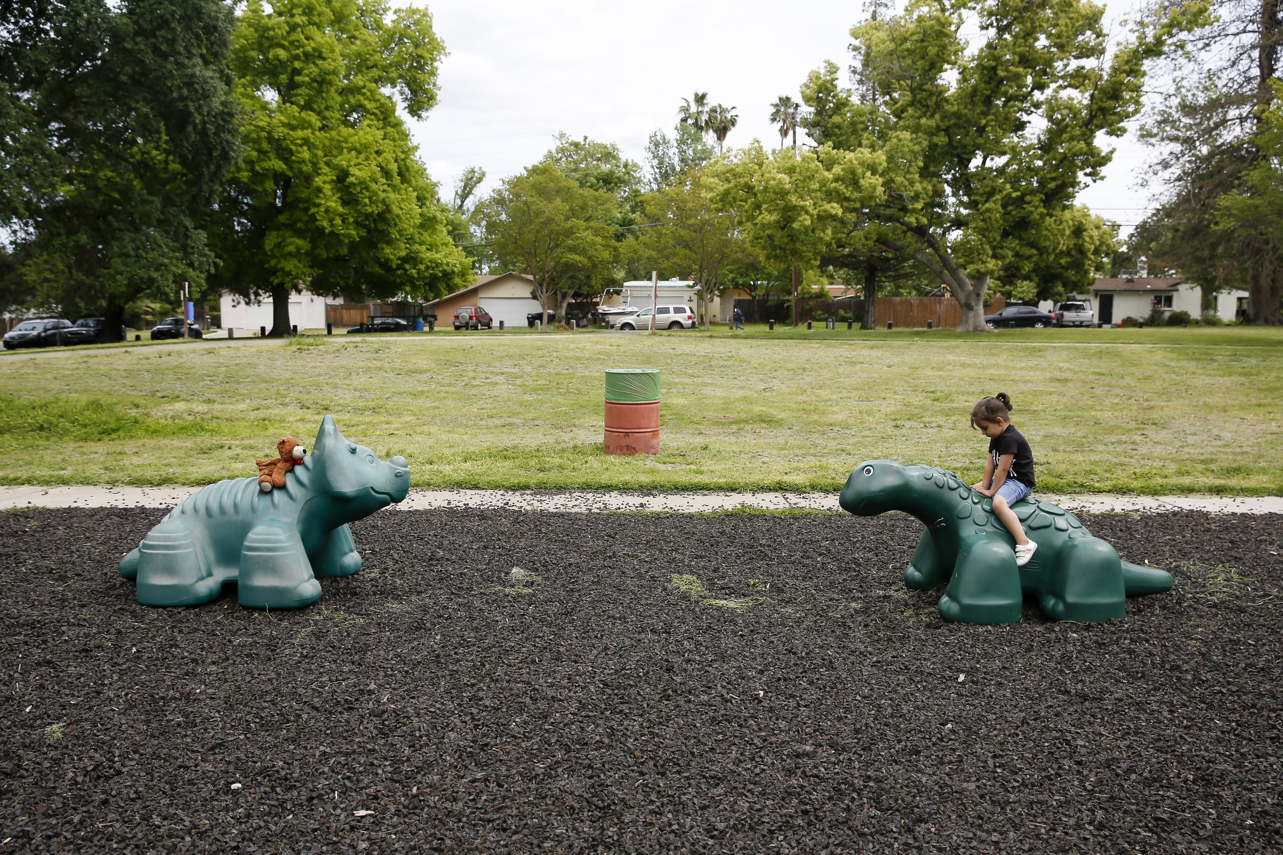  Zahra Mohammadi (3) plays by herself on a a toy dinosaur with her stuffed bear at a playground in Sacramento, Calif.  on Wednesday, April 13, 2022. Najibullah Mohammadi, his wife Susan, their two young children Zahra and Yasar, and their soon-to-be 