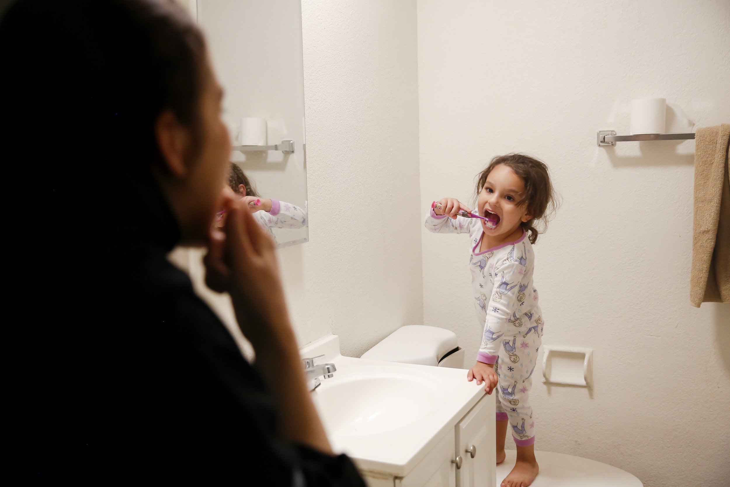  Zahra Mohammadi (3) brushes her teeth while her mother, Susan Mohammadi, watches at their home in Sacramento, Calif. on Thursday, April 21, 2022. Najibullah Mohammadi, his wife Susan, their two young children Zahra and Yasar, and their soon-to-be bo