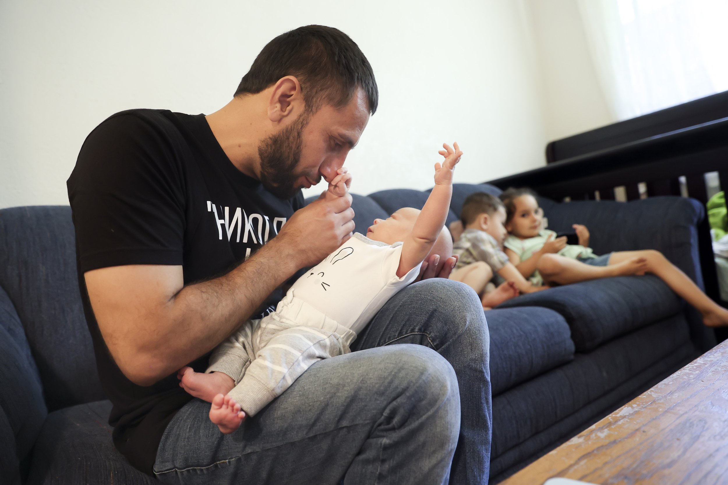  Najibullah Mohamamdi plays with his newborn son, Yusuf Mohammadi at home in Sacramento, Calif. on Tuesday, may 31, 2022. Najibullah Mohammadi, his wife Susan, their two young children Zahra and Yasar, and their soon-to-be born third child Yusuf  imm