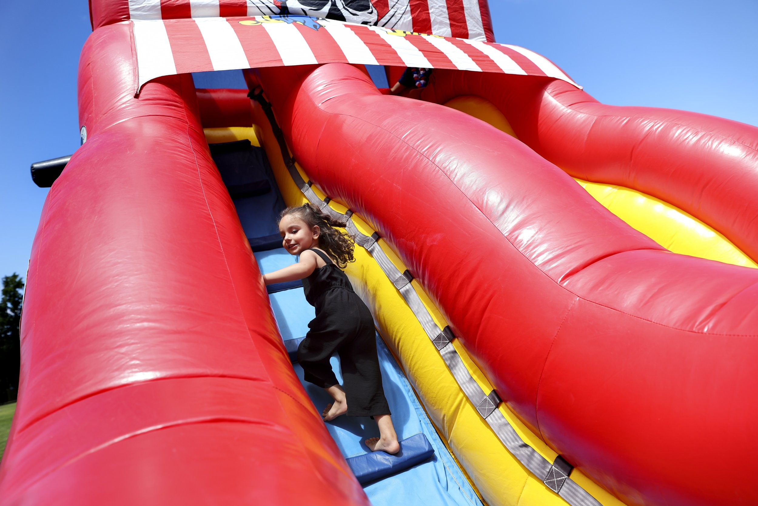  Zahra Mohammadi climbs an inflatable slide at a Fourth of July celebration in Sacramento, Calif.  on Monday, July 4, 2022. Najibullah Mohammadi, his wife Susan, their two young children Zahra and Yasar, and their soon-to-be born third child Yusuf  i