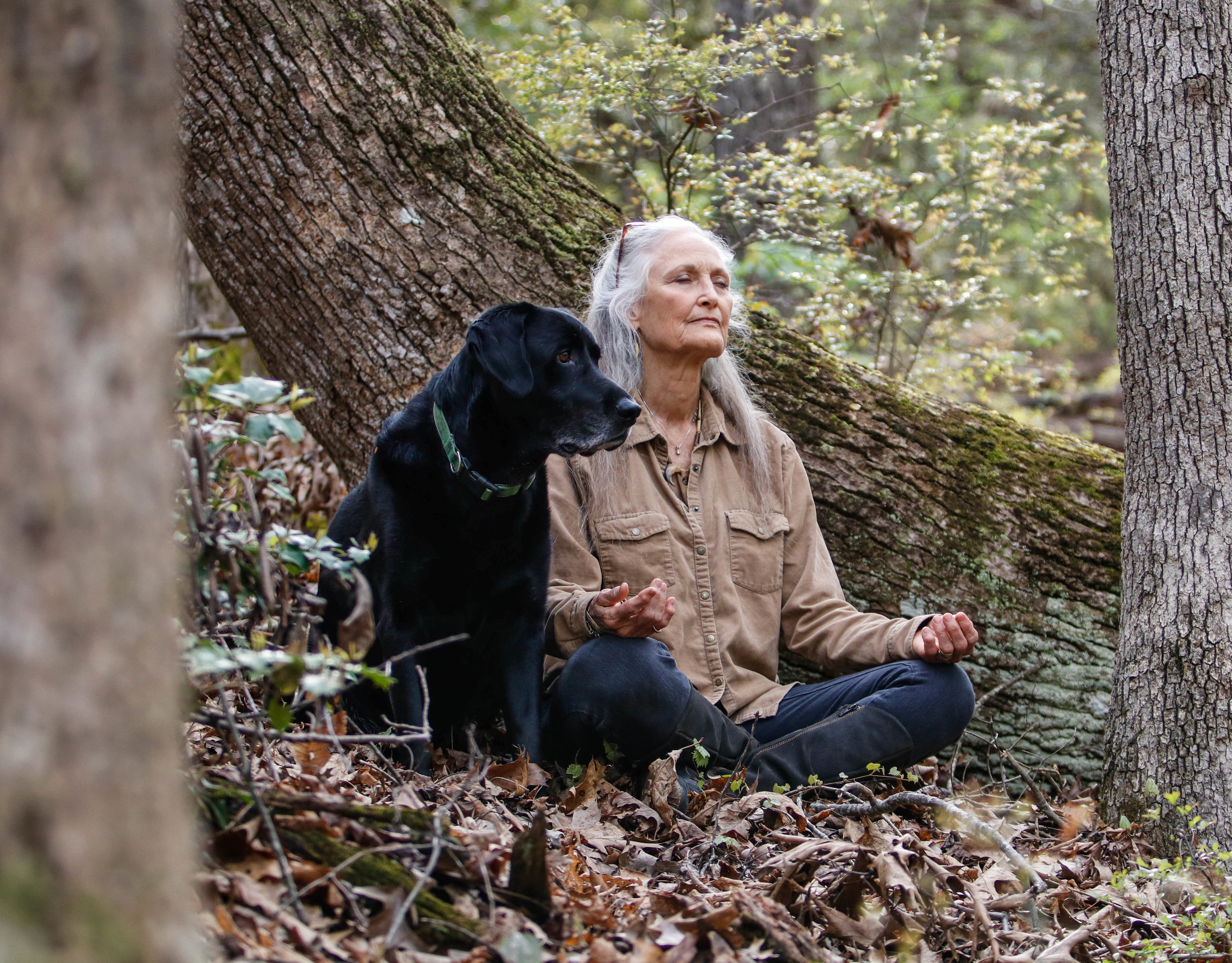 Tinsley mediates with her dog Beaux in one of the many secluded wooded areas of Earthsong on Saturday, April 7, 2018.  