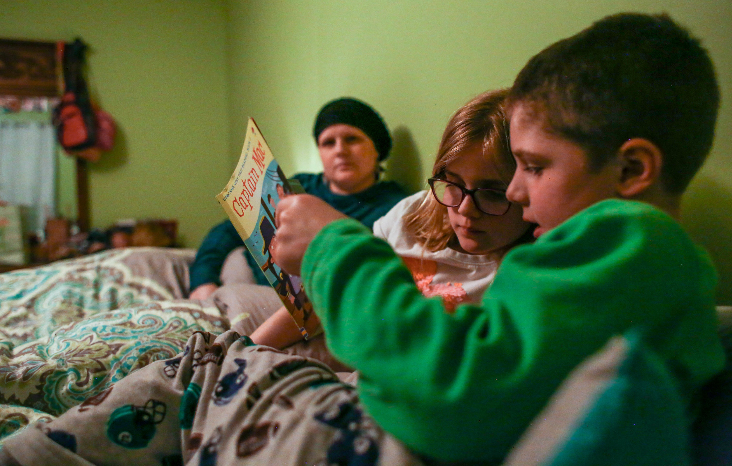 Amanda Cihak watches her children Cameron and Kayla read together before bed as part of their nightly routine at their house, in Muskegon, Michigan on Tuesday, March 26, 2019. Ever since Amanda was diagnosed with cancer, her kids sleep in her bed wi