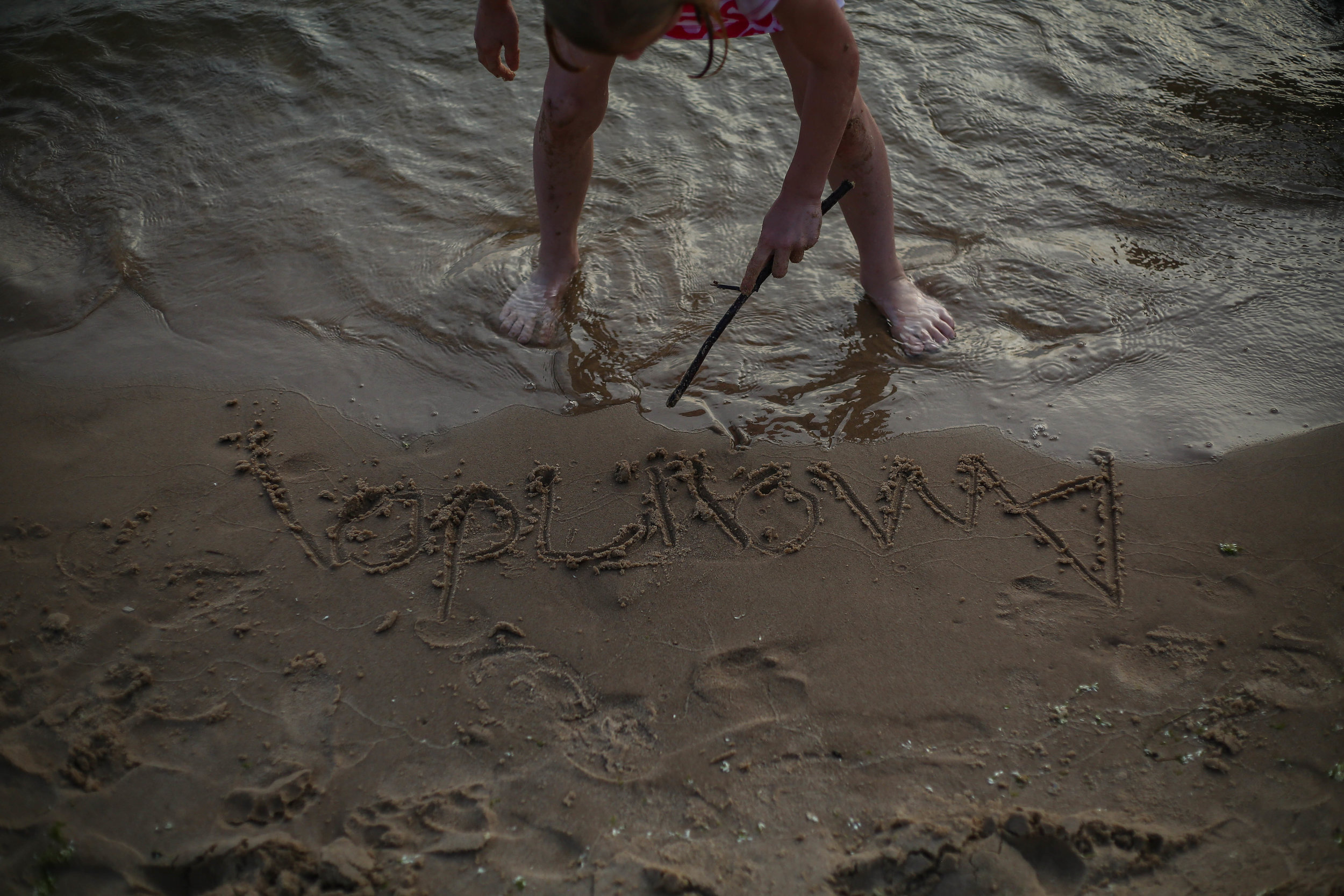  Amanda’s daughter Kayla uses a stick to draw a ribbon, the cancer symbol, beneath her mom’s name, but the water washes it away, at Muskegon State Park, in Muskegon, Michigan on Sunday, June 30, 2019. 