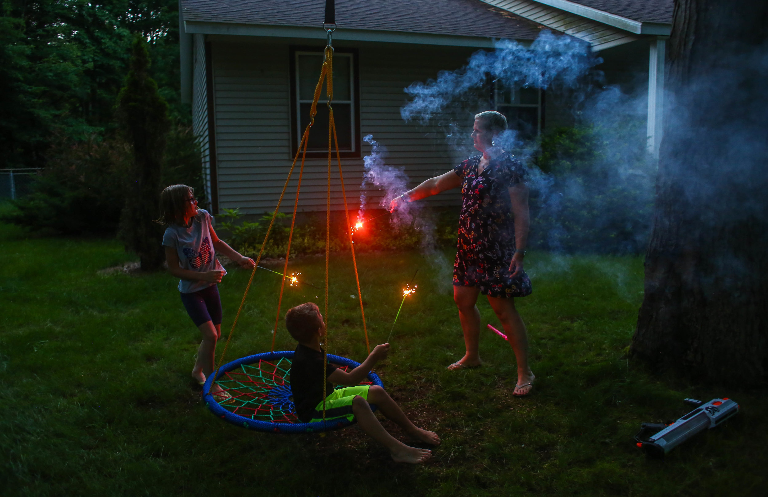  Amanda Cihak and her children Cameron and Kayla celebrate the Fourth of July early with some sparklers in their front yard, in Muskegon, Michigan on Sunday, June 30, 2019. 