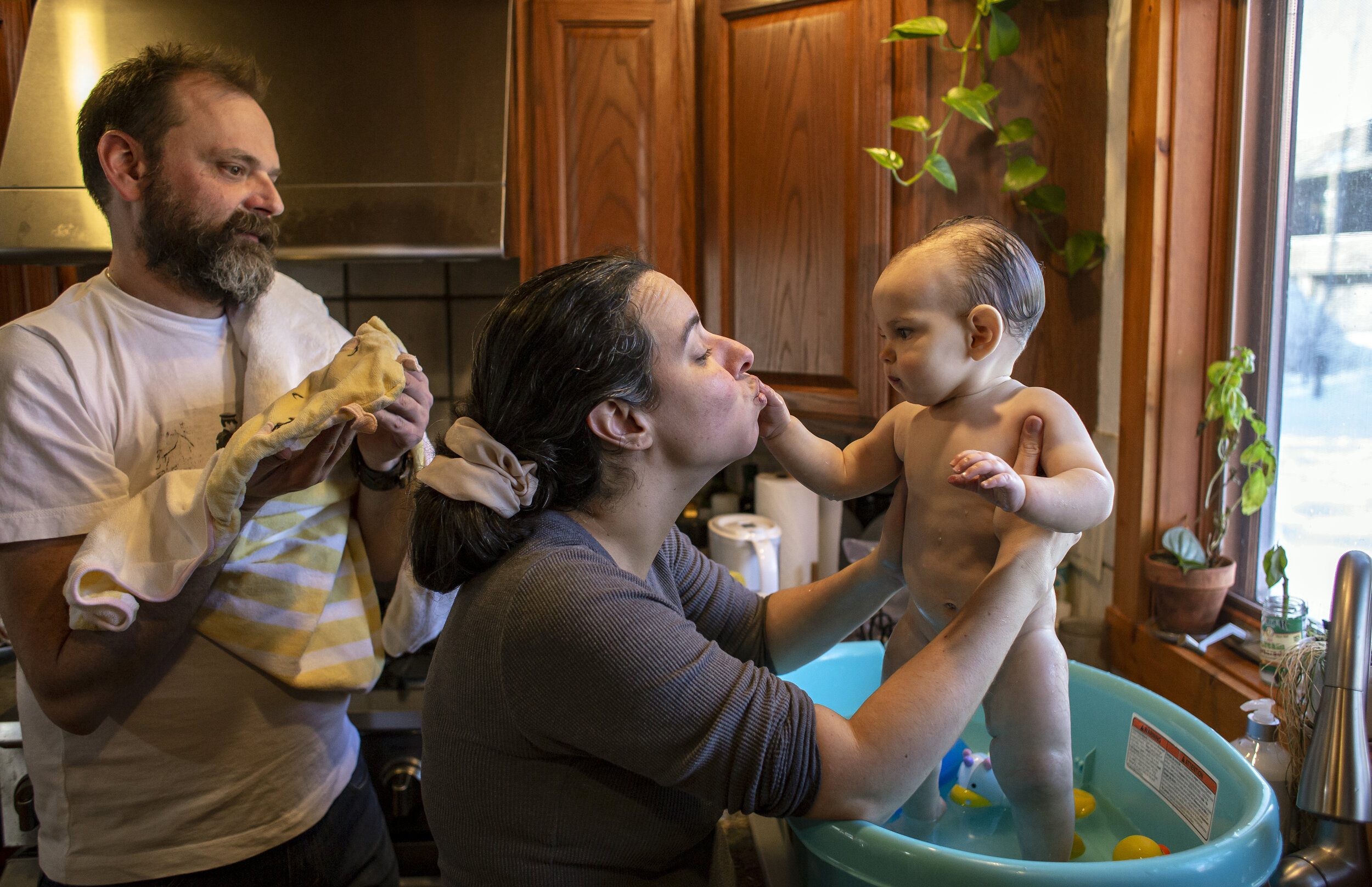  Souza kisses Isadora’s fingers as she and Metcalf prepare to take her out of the bath on Jan. 1, 2021. Playing in the water during bath time is one of Isadora’s favorite activities.  