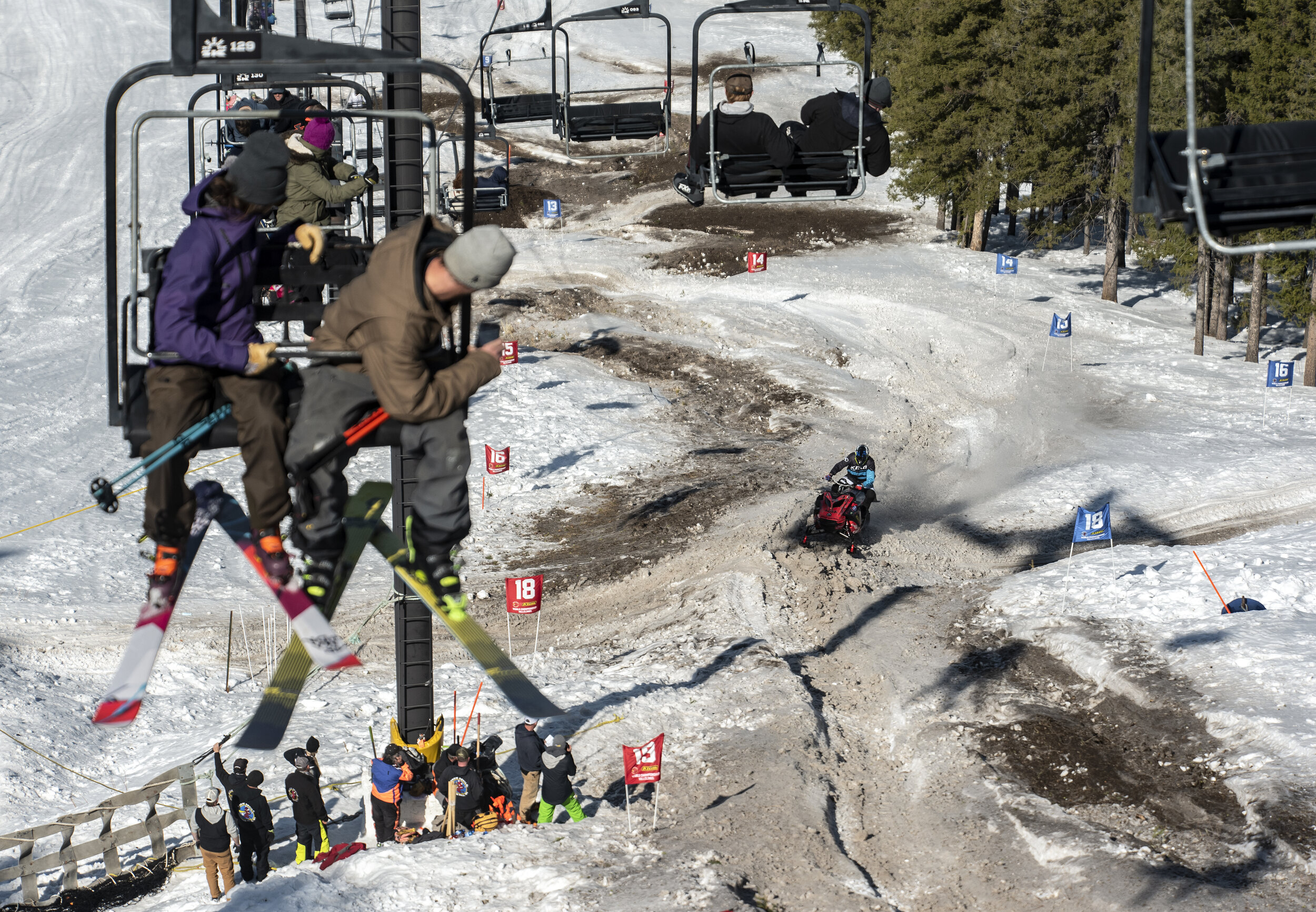 Skiers watch from the Summit Chair Lift as Brad Sharp makes his way through the course during the 900 modified division at the 44th World Championship Snowmobile Hill Climb at Snow King Mountain in Jackson, Wy. on March 31, 2021.