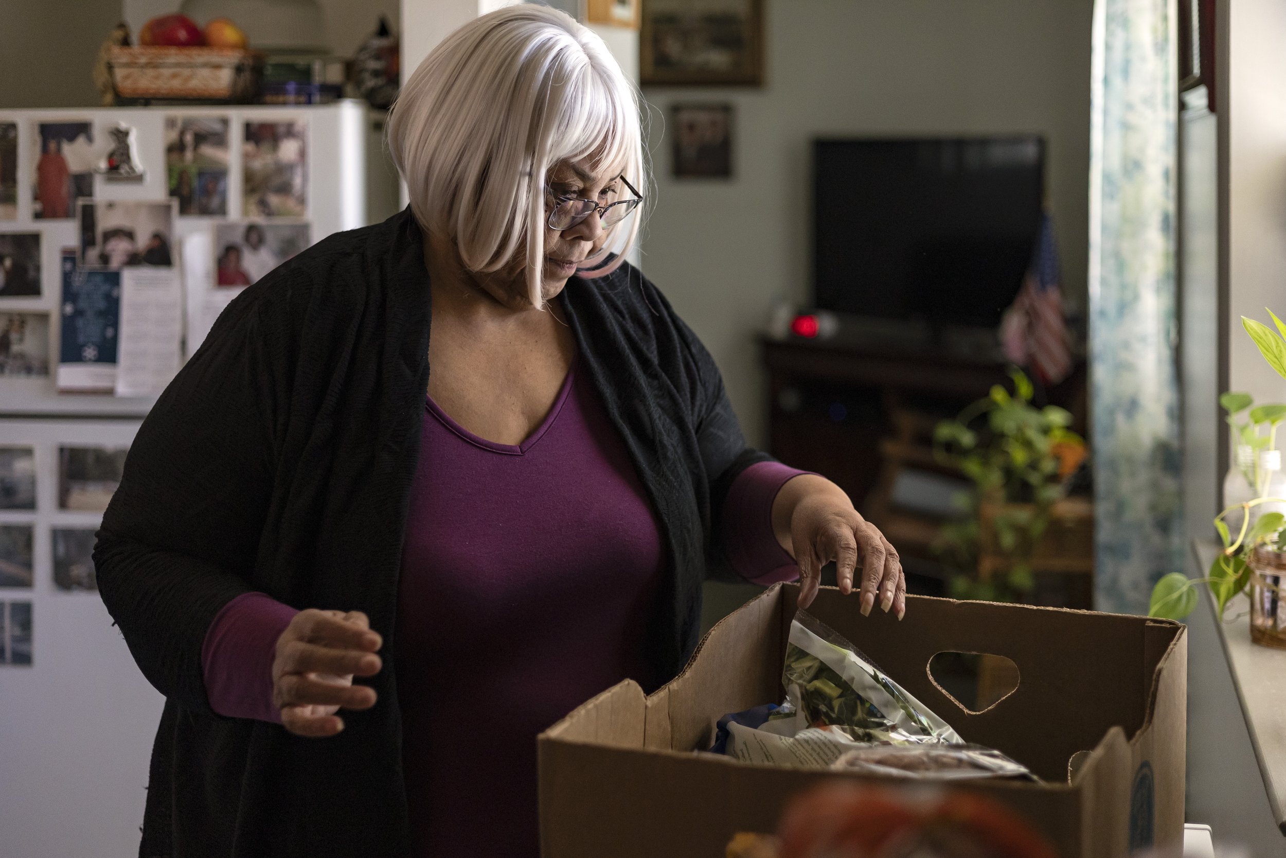 Carol Oliver, an Athens resident of almost 40 years, reviews her weekly box of food donations delivered by volunteers from Mt. Olive Seventh-day Adventist Church at Parkview Homes on Tuesday, March 1, 2022 in Athens. Oliver, who has been receiving f