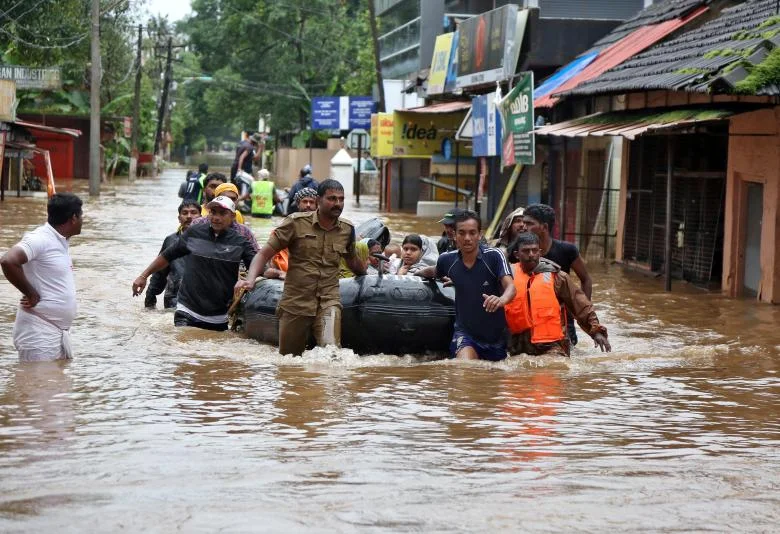 Rescuers evacuate people from a flooded area to a safer place in Aluva, August 18, 2018. REUTERS/Sivaram V