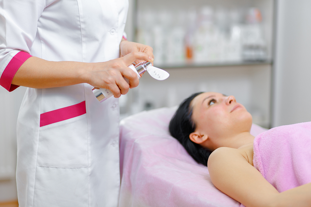 Young woman beautician is doing the cleaning procedure