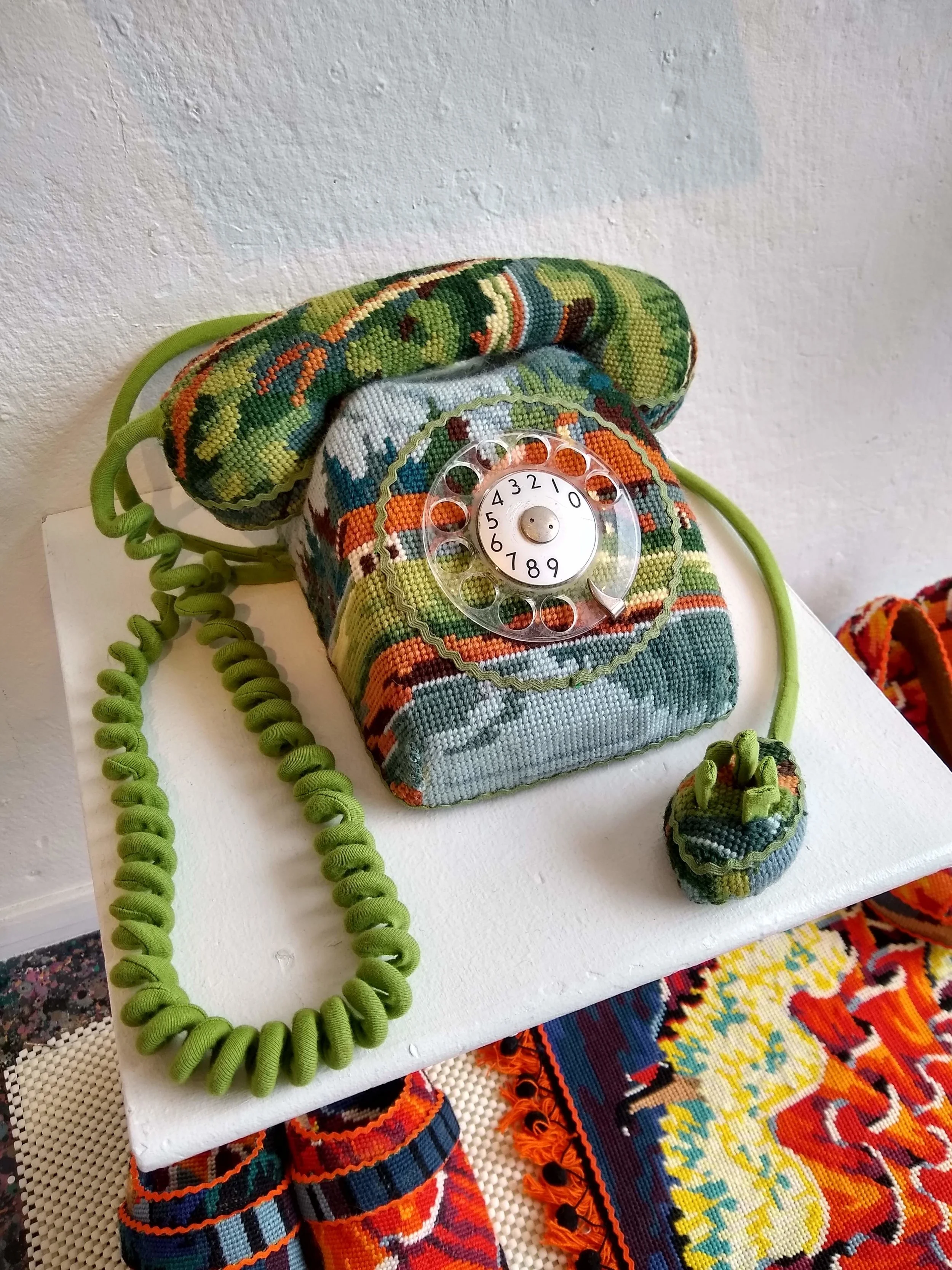 Rotary telephone covered in flea market find embroidery