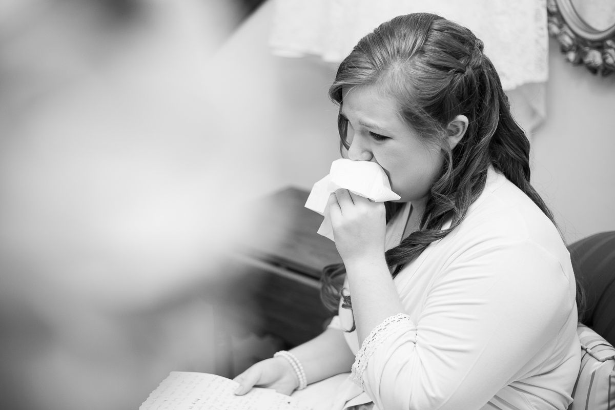 Bride crying while reading love letter from the groom.