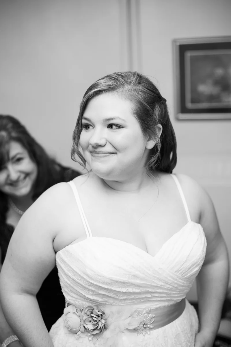 Mother of the bride helping bride get ready before the wedding ceremony. 