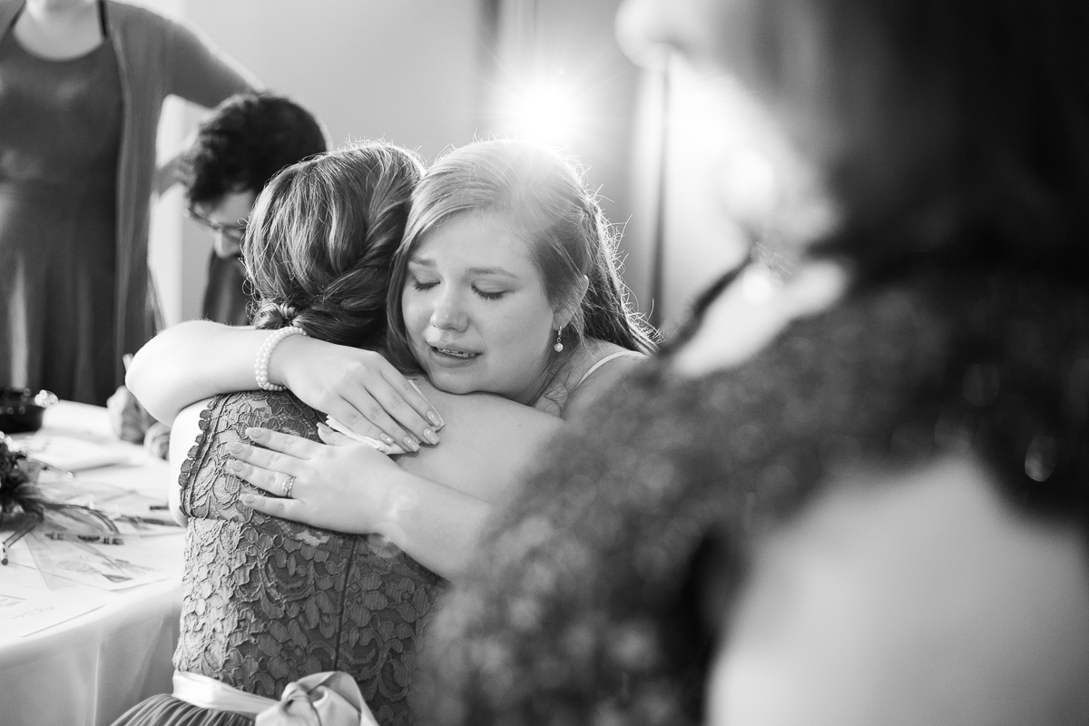Bride and bridesmaid crying at wedding reception