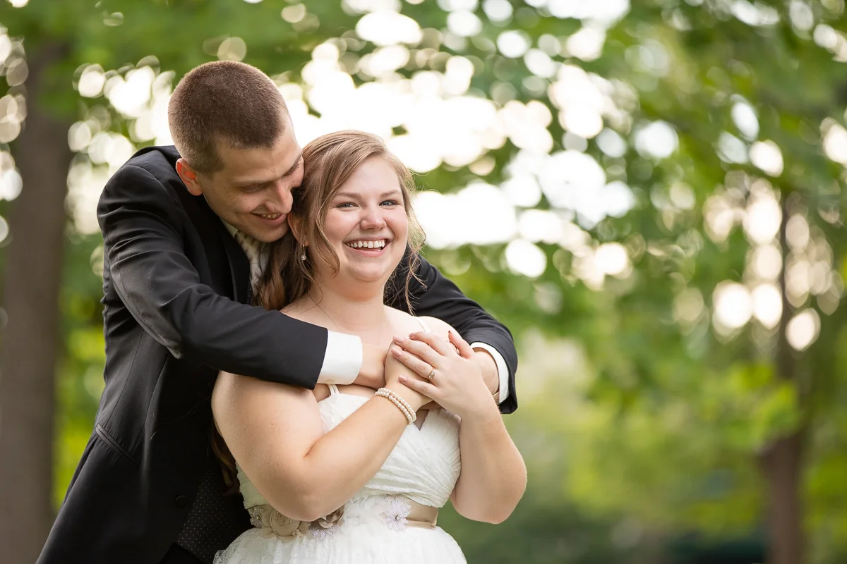 Bride and groom laughing during formal photos. 