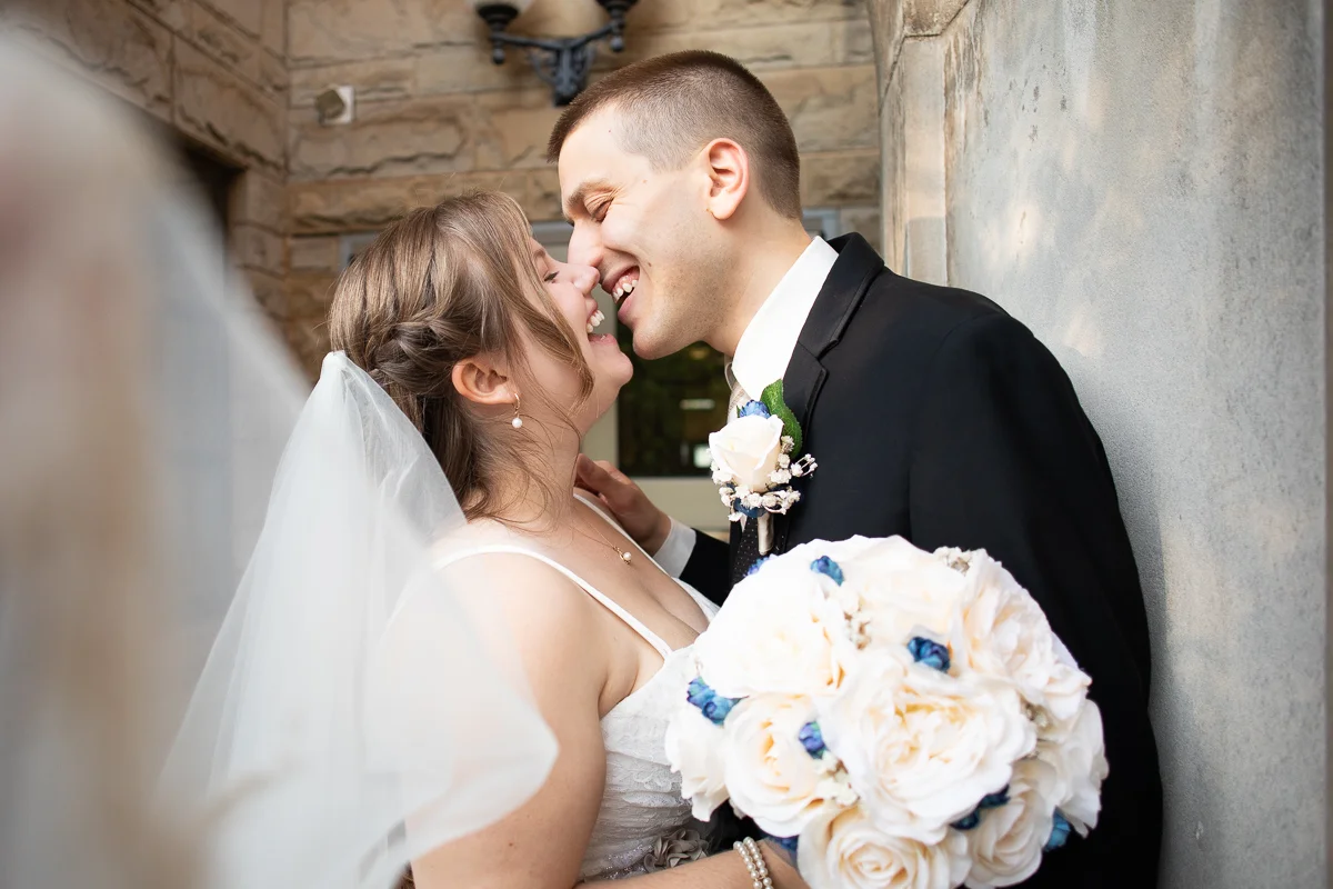 Bride and groom laughing during formal photos. 