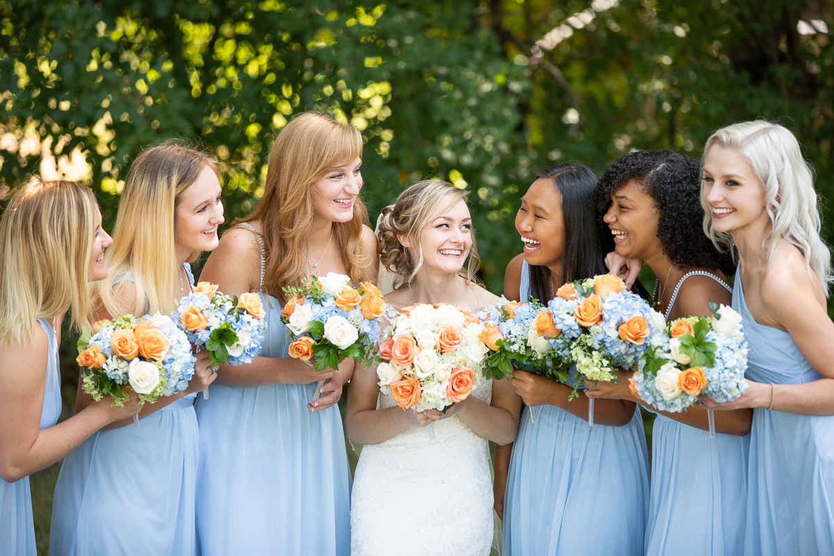 Bride and bridesmaids laughing during formal photos. 